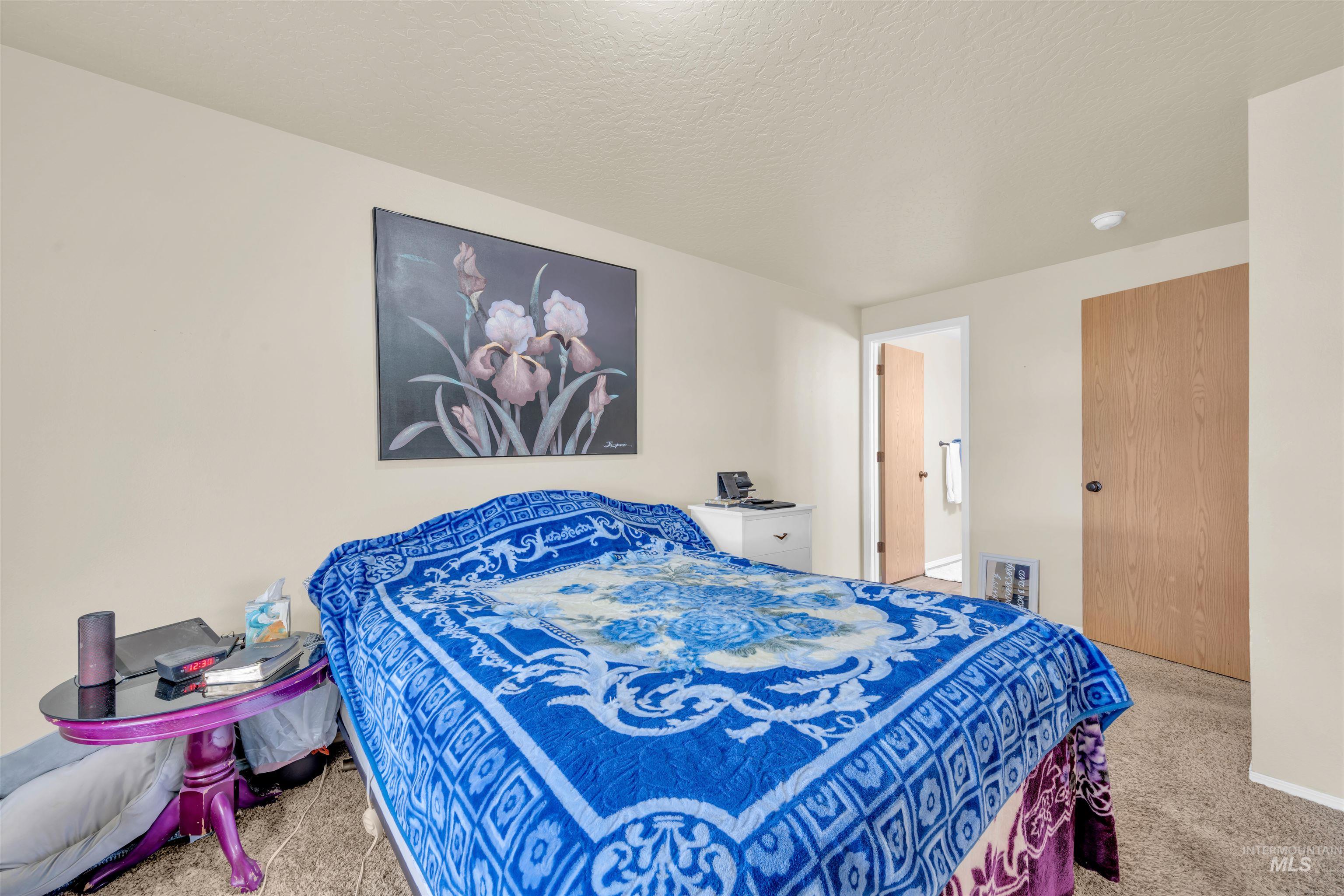 Carpeted bedroom with a textured ceiling