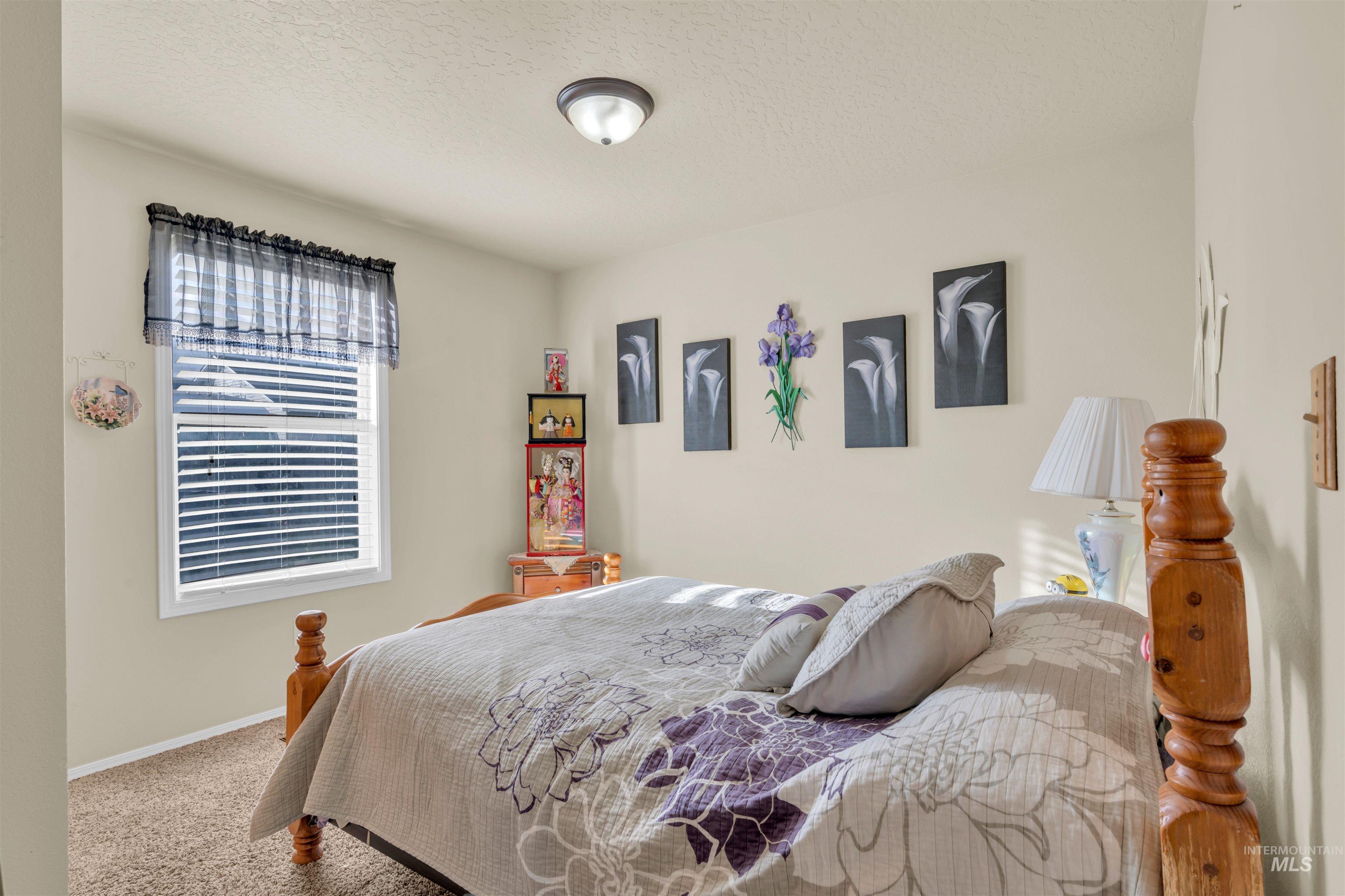 Bedroom featuring a textured ceiling and carpet flooring