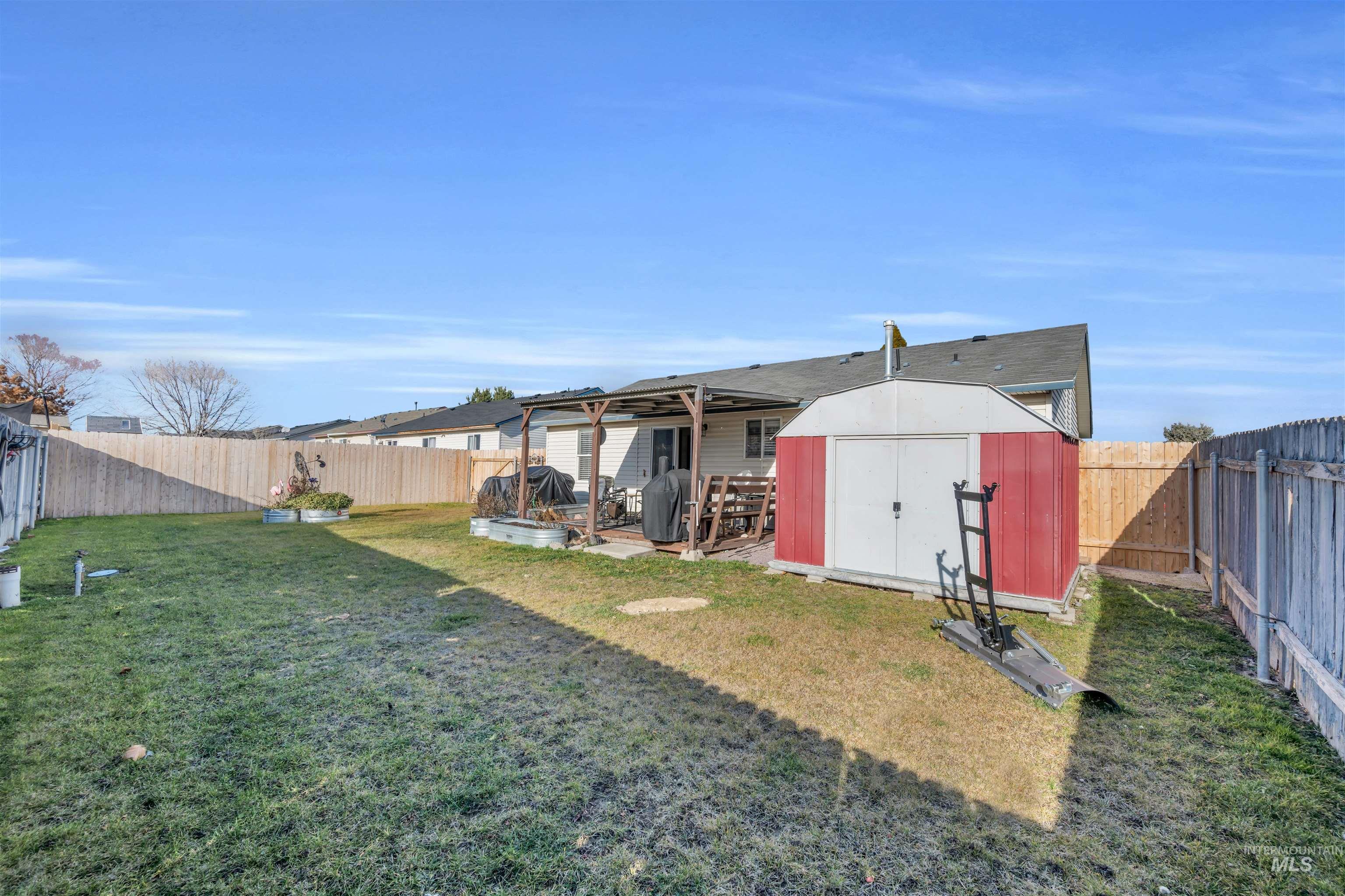 Fenced backyard with a shed and a wooden deck