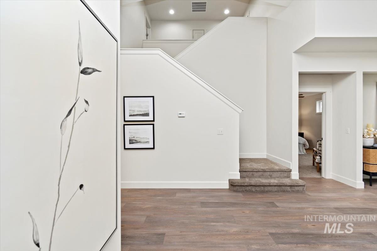 Staircase with wood finished floors and recessed lighting