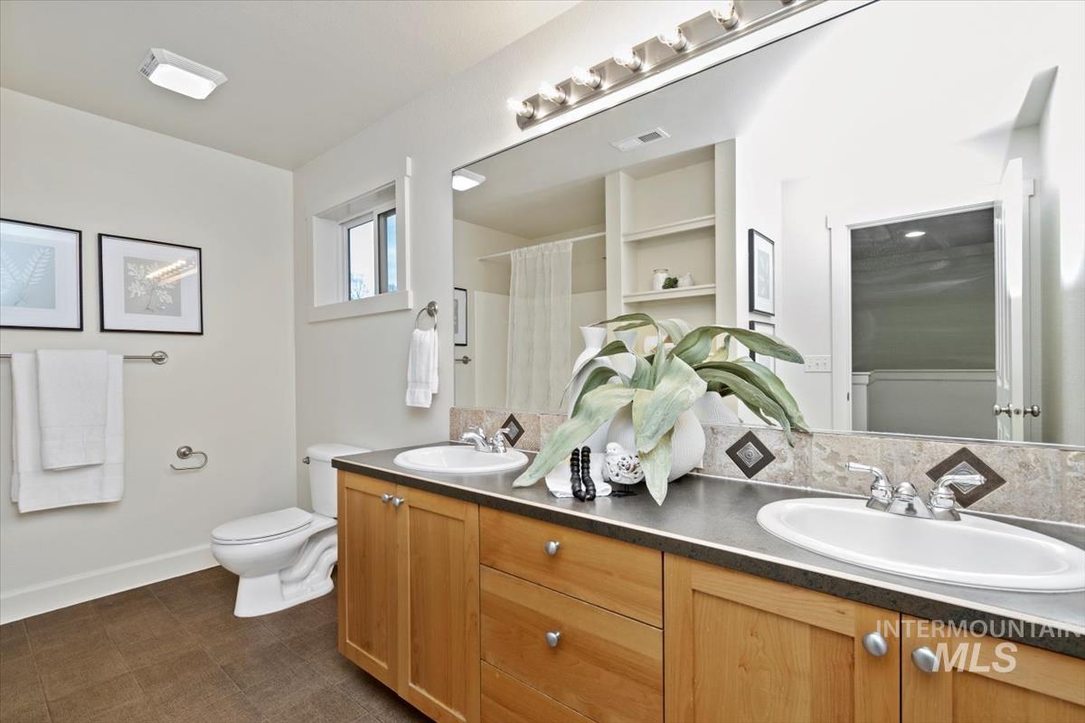 Bathroom featuring double vanity and curtained shower
