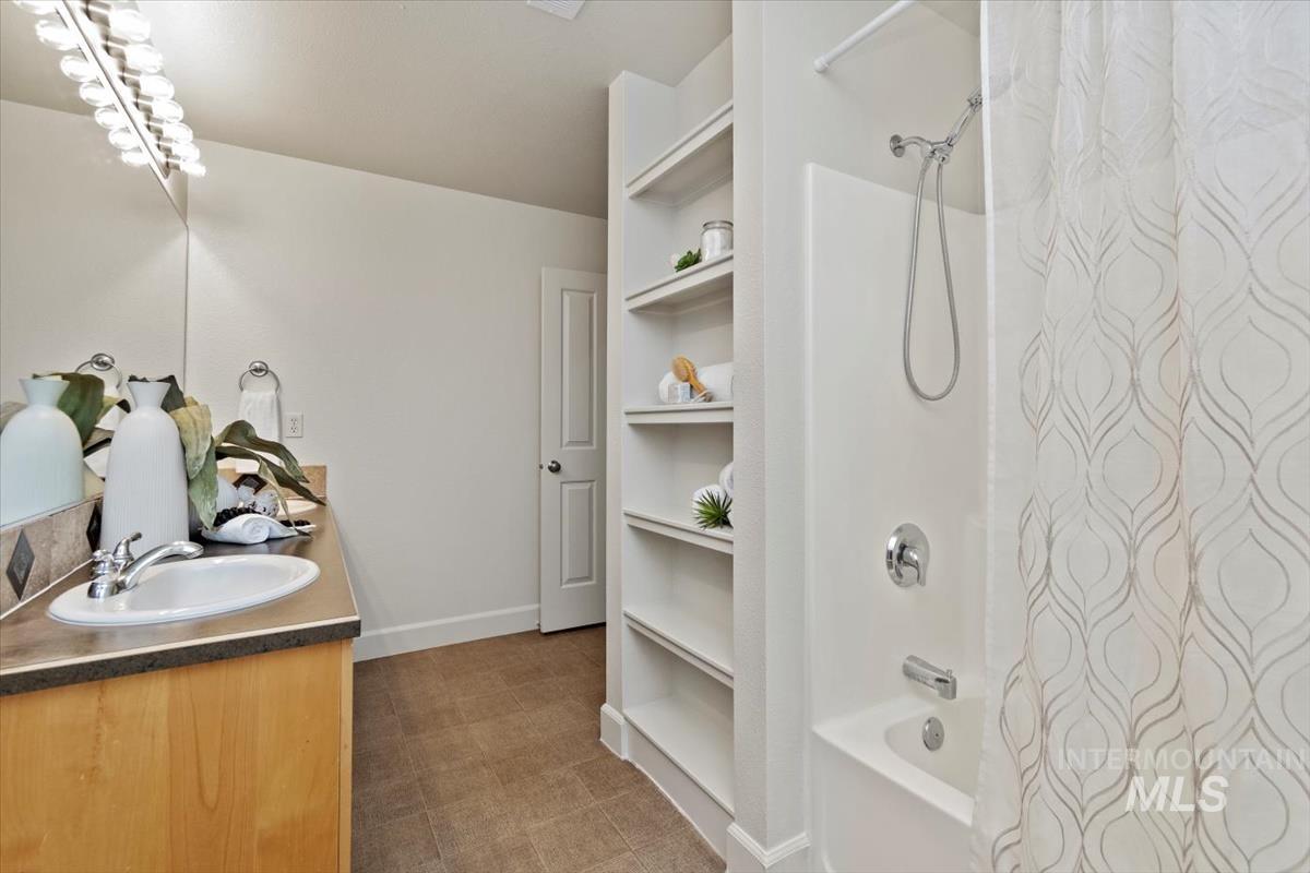 Full bath featuring shower / bathtub combination with curtain and double vanity