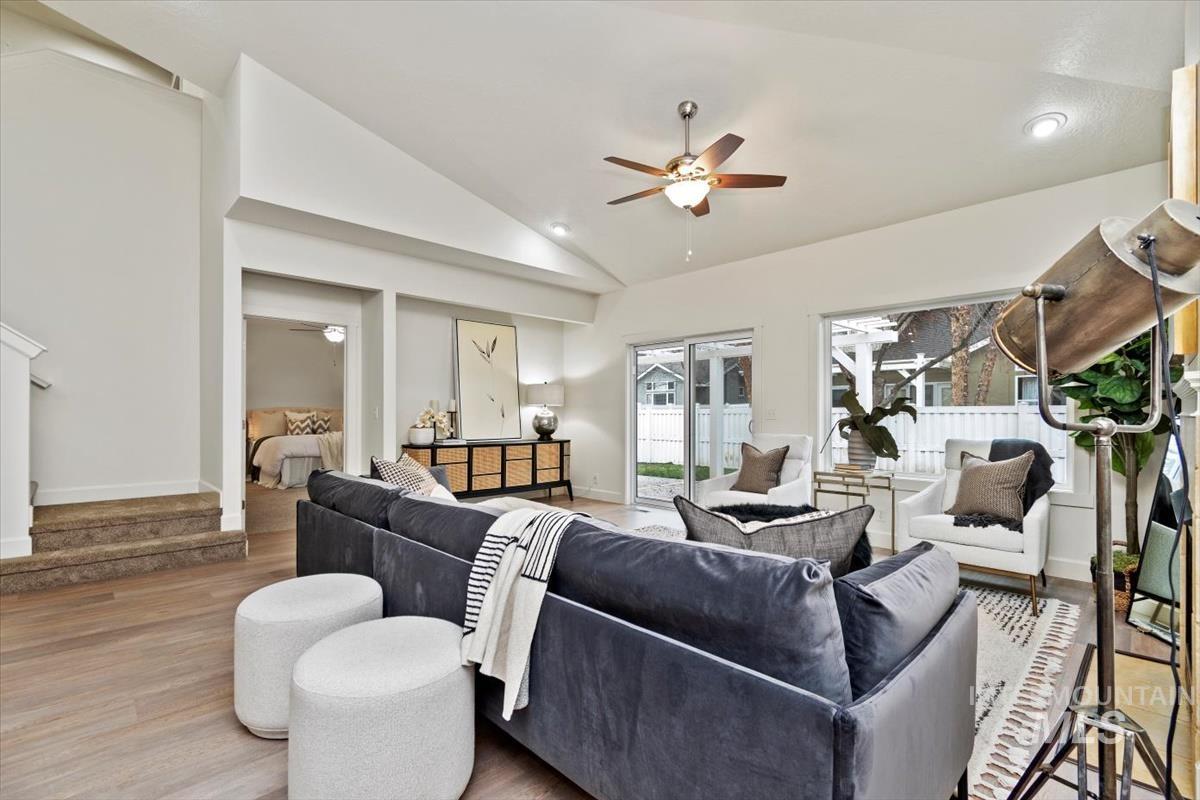 Living room with ceiling fan, light wood-style floors, recessed lighting, stairway, and high vaulted ceiling