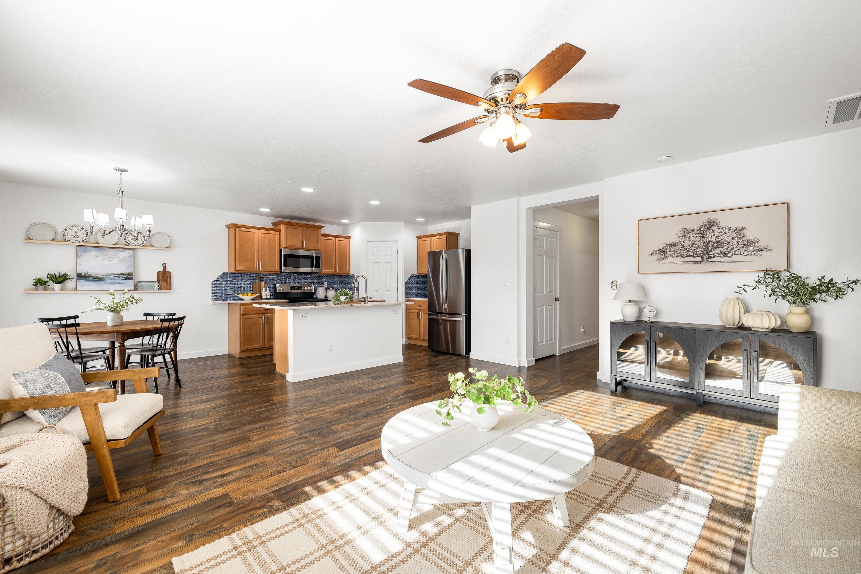 Living room featuring recessed lighting, dark wood-style floors, a chandelier, and a ceiling fan