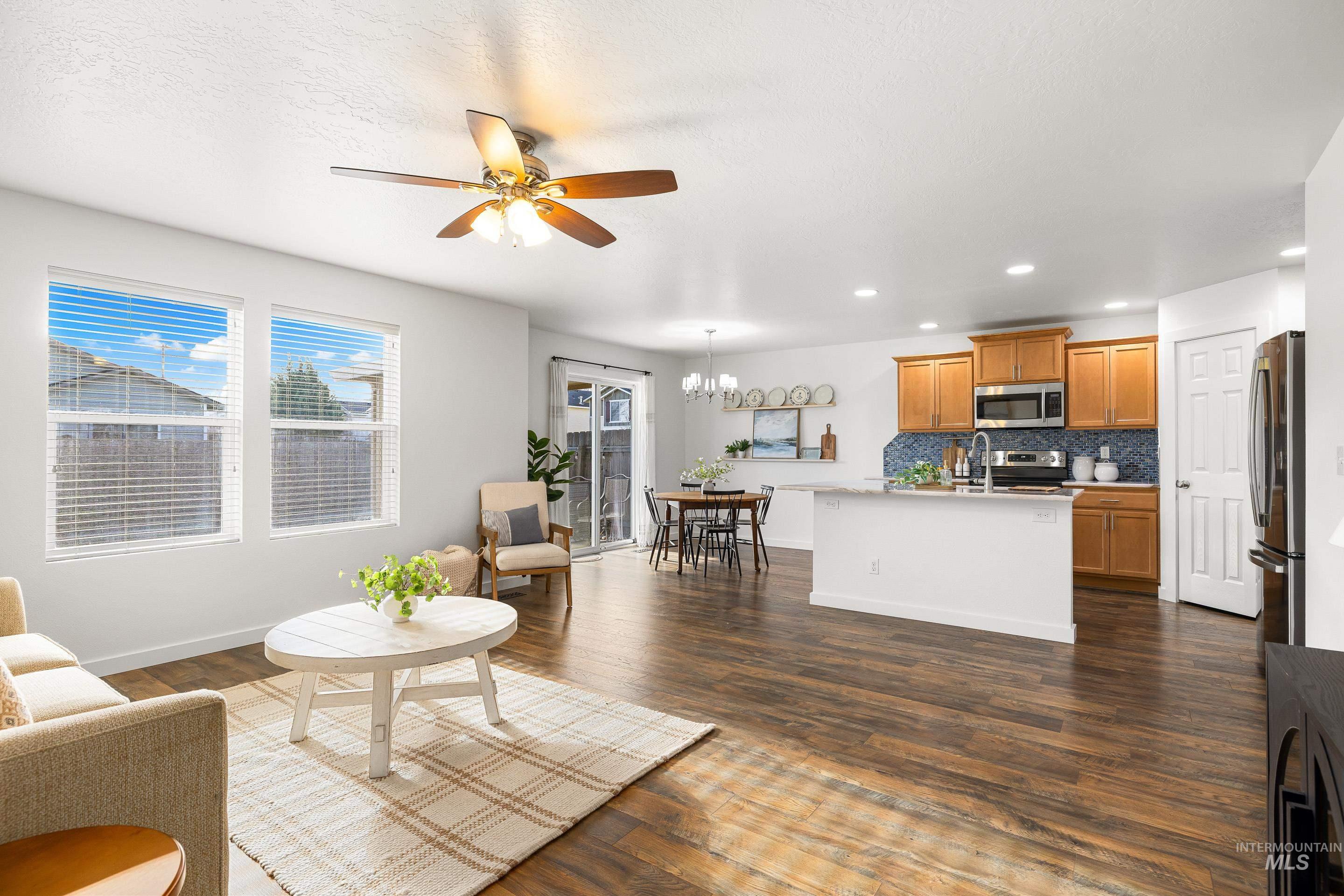 Living area featuring recessed lighting, a chandelier, ceiling fan, and dark wood finished floors