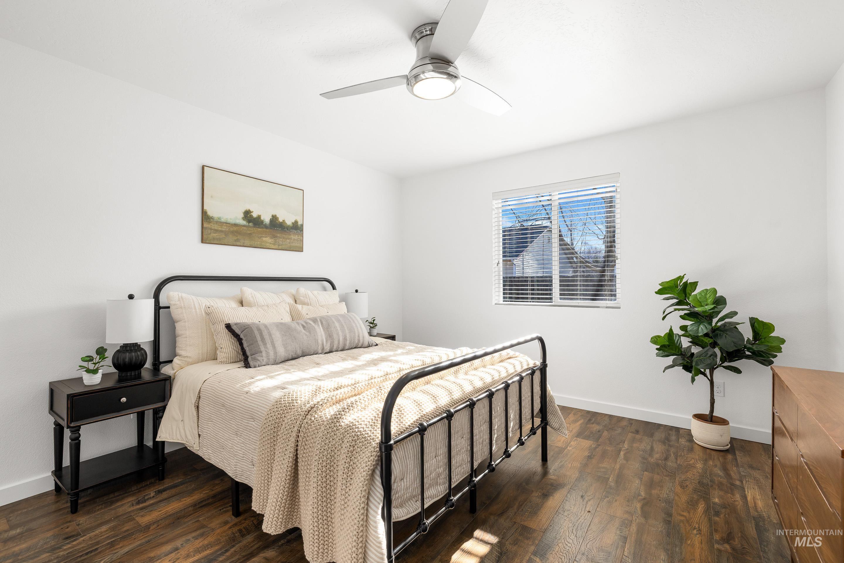 Bedroom with dark wood-style flooring and ceiling fan