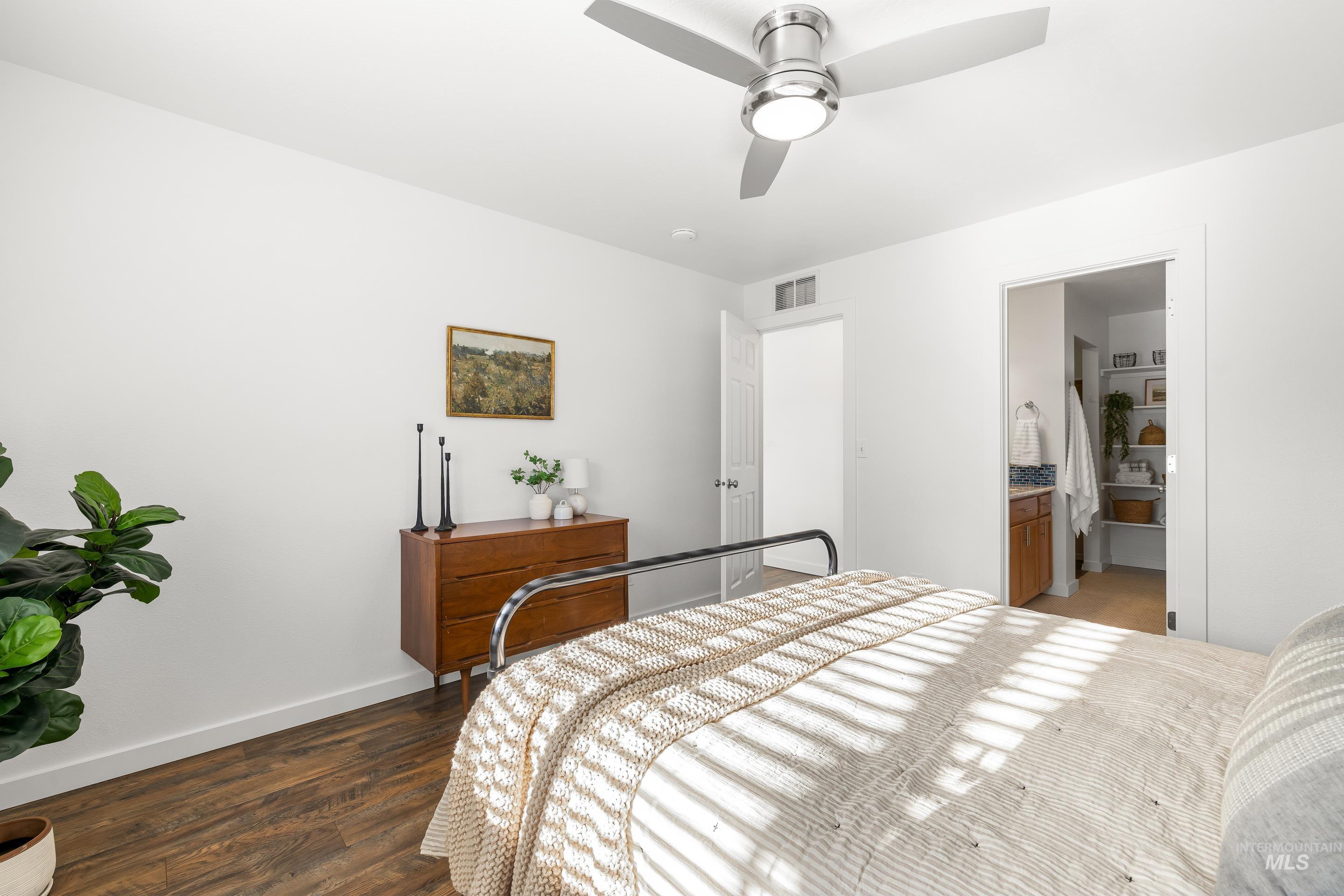 Bedroom featuring dark wood finished floors, ceiling fan, and connected bathroom