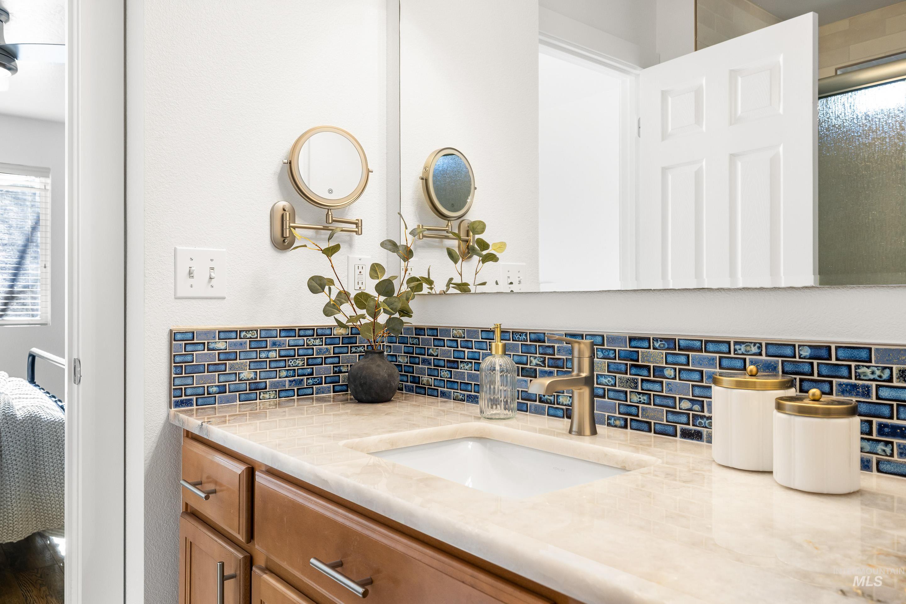 Bathroom with decorative backsplash, connected bathroom, and vanity