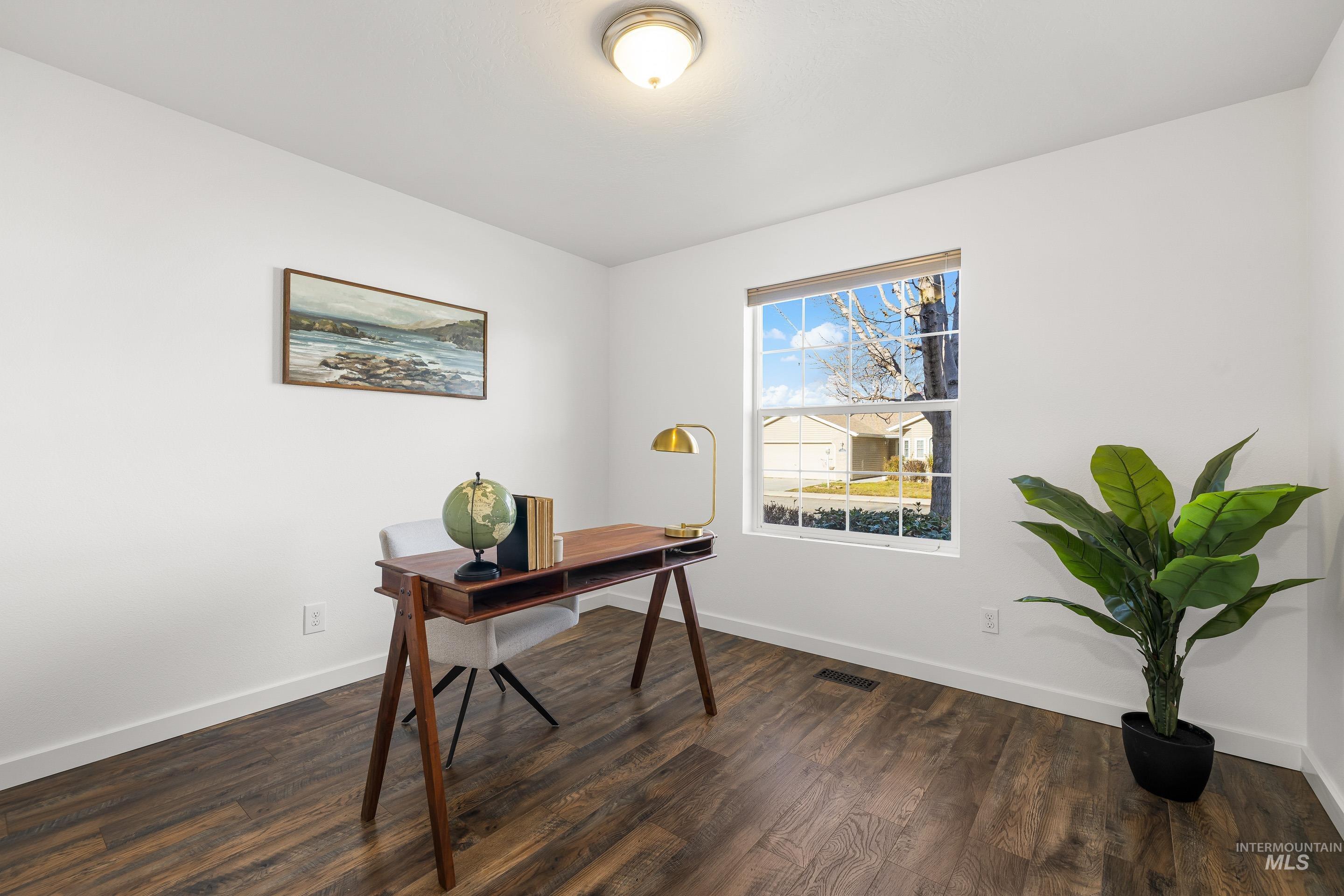 Home office with dark wood-style floors and baseboards