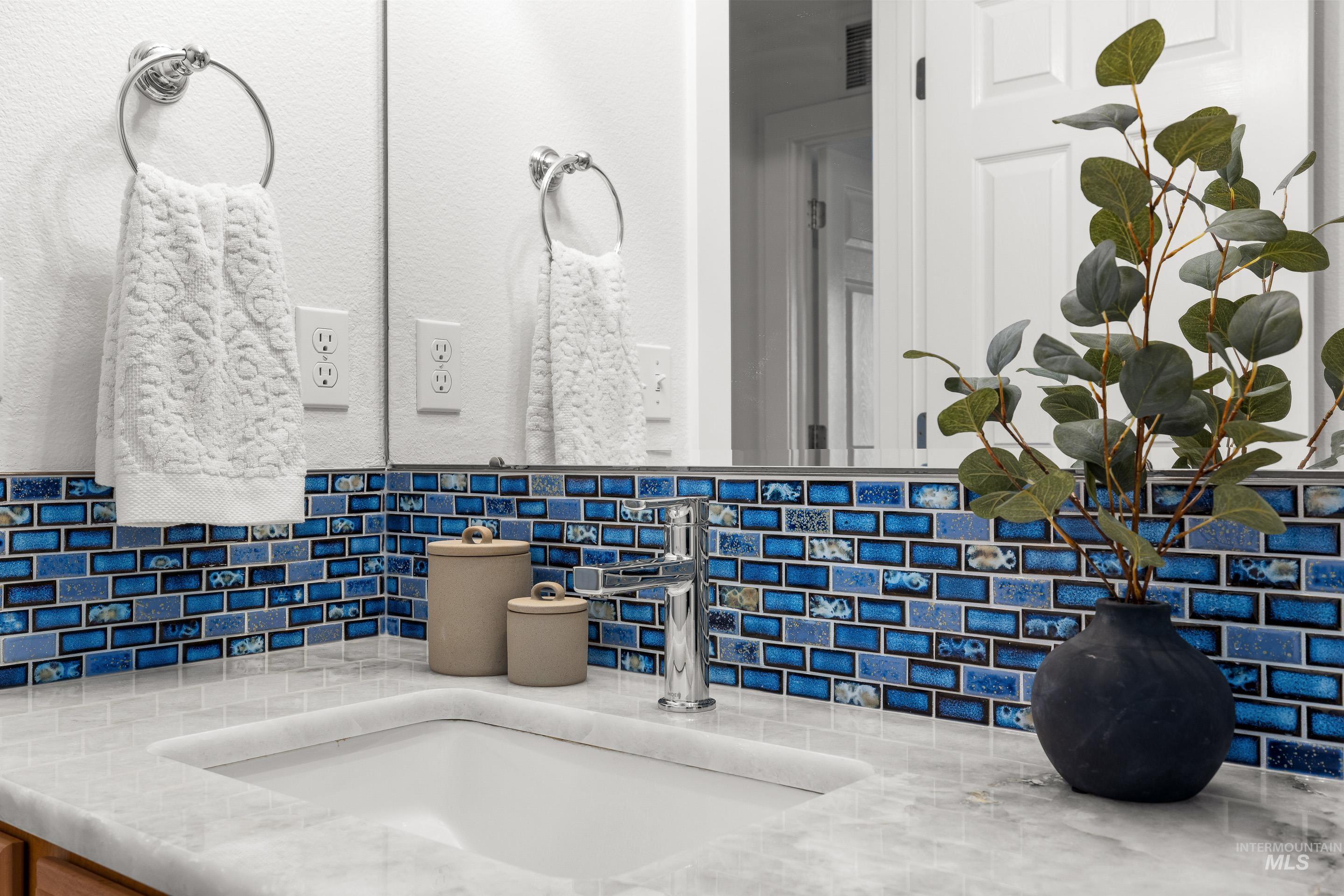 Bathroom view of vanity and tasteful backsplash