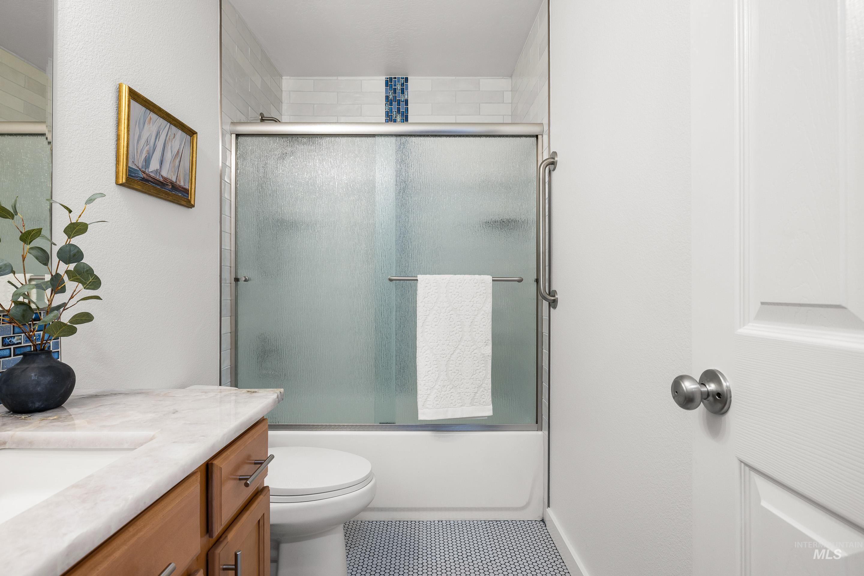 Bathroom with vanity and enclosed tub / shower combo