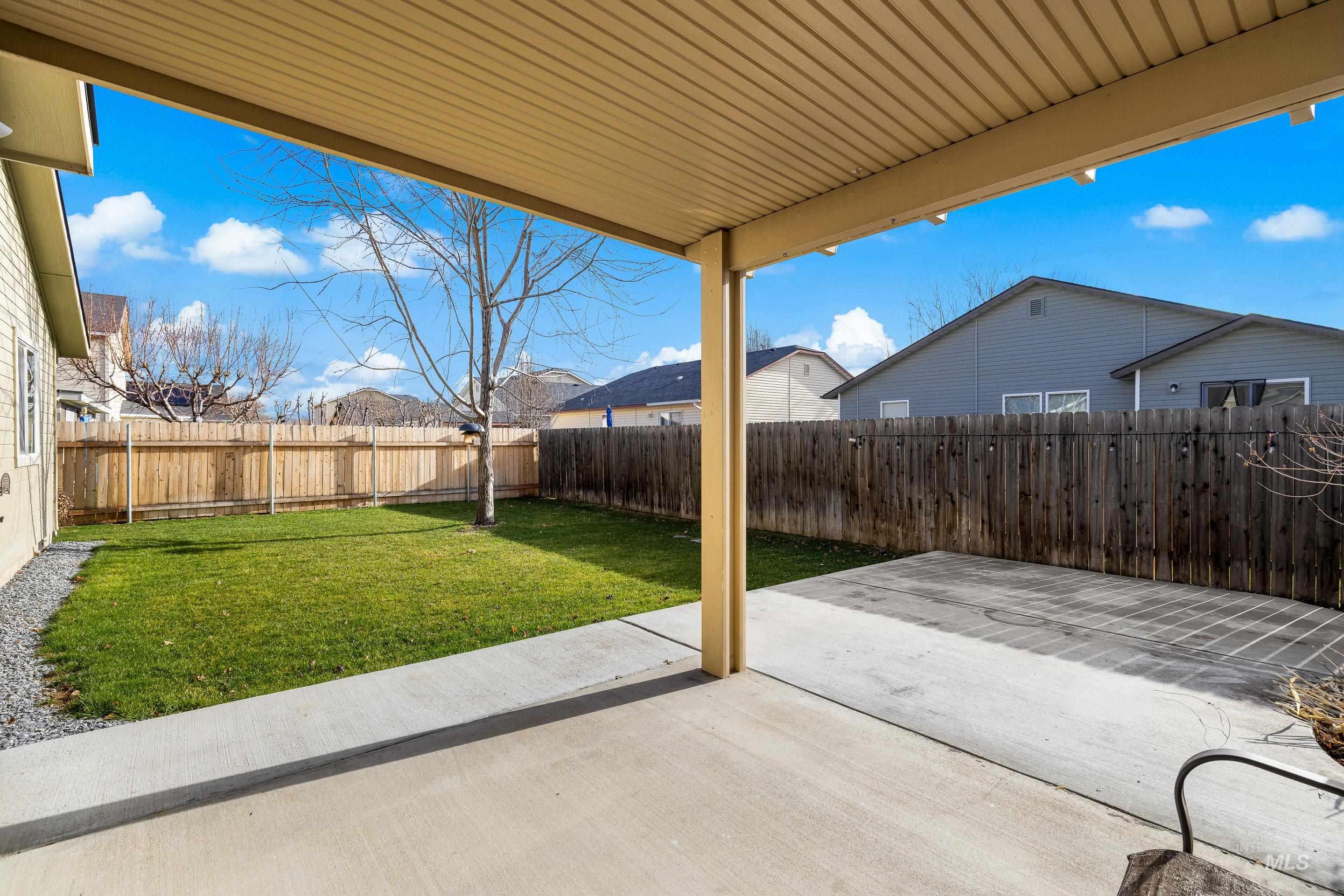 Fenced backyard featuring a patio area and a residential view
