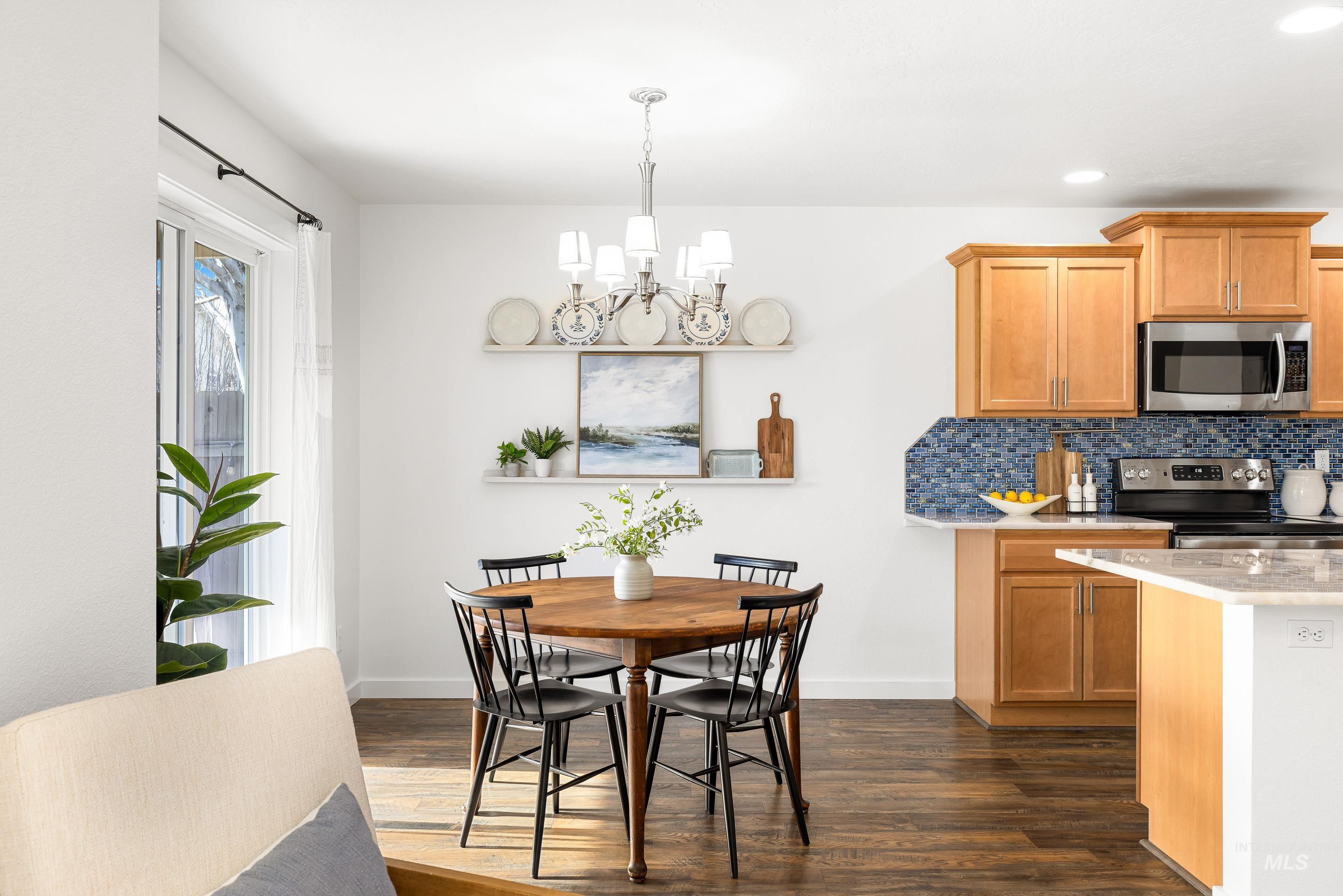 Dining area with dark wood finished floors, a chandelier, and recessed lighting