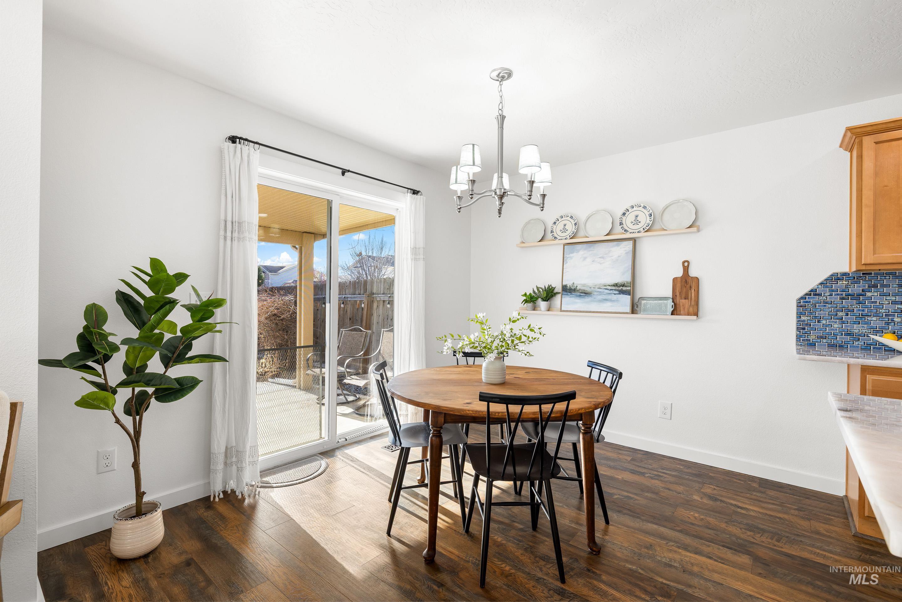 Dining space featuring dark wood-type flooring and a chandelier