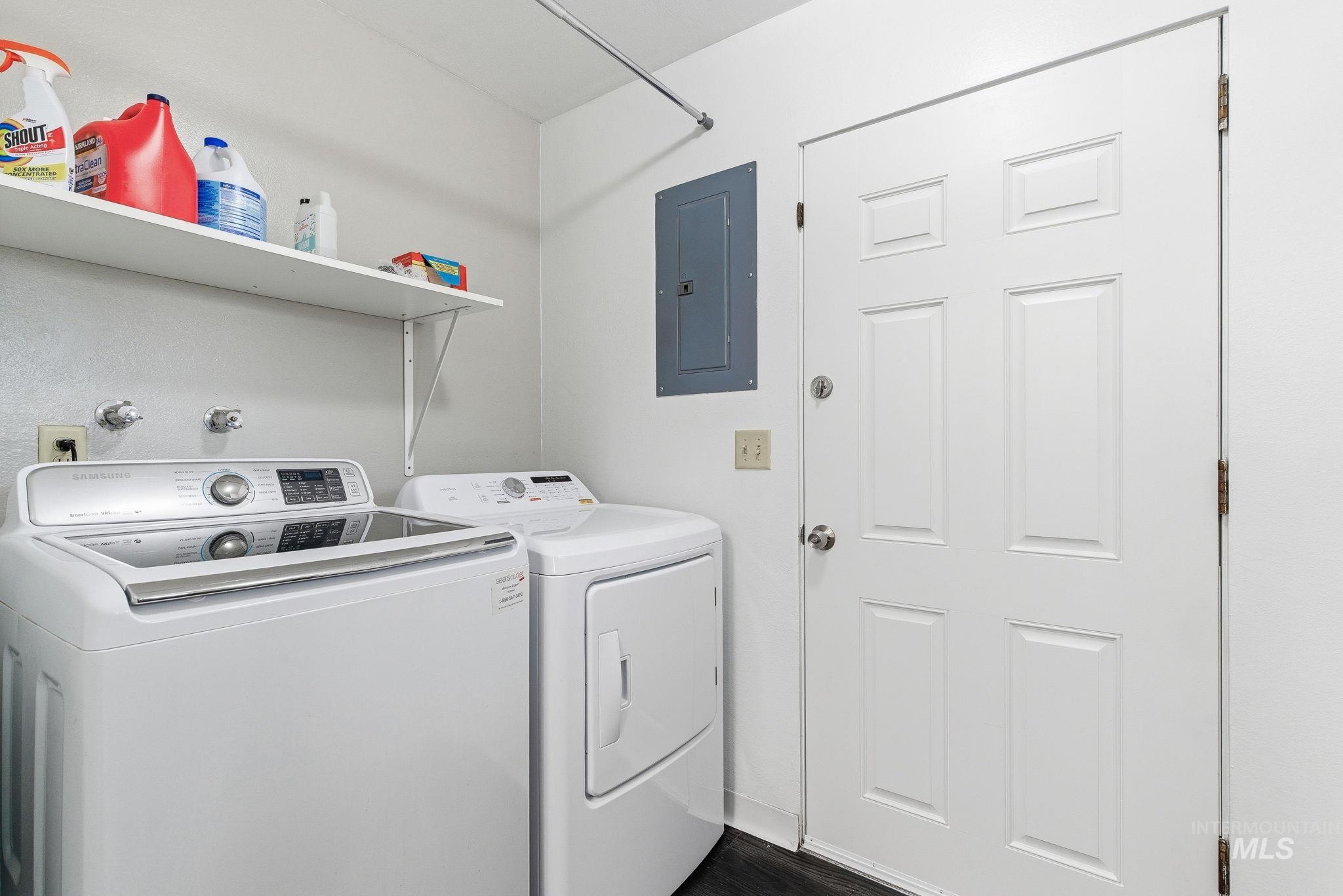 Laundry room featuring electric panel and separate washer and dryer