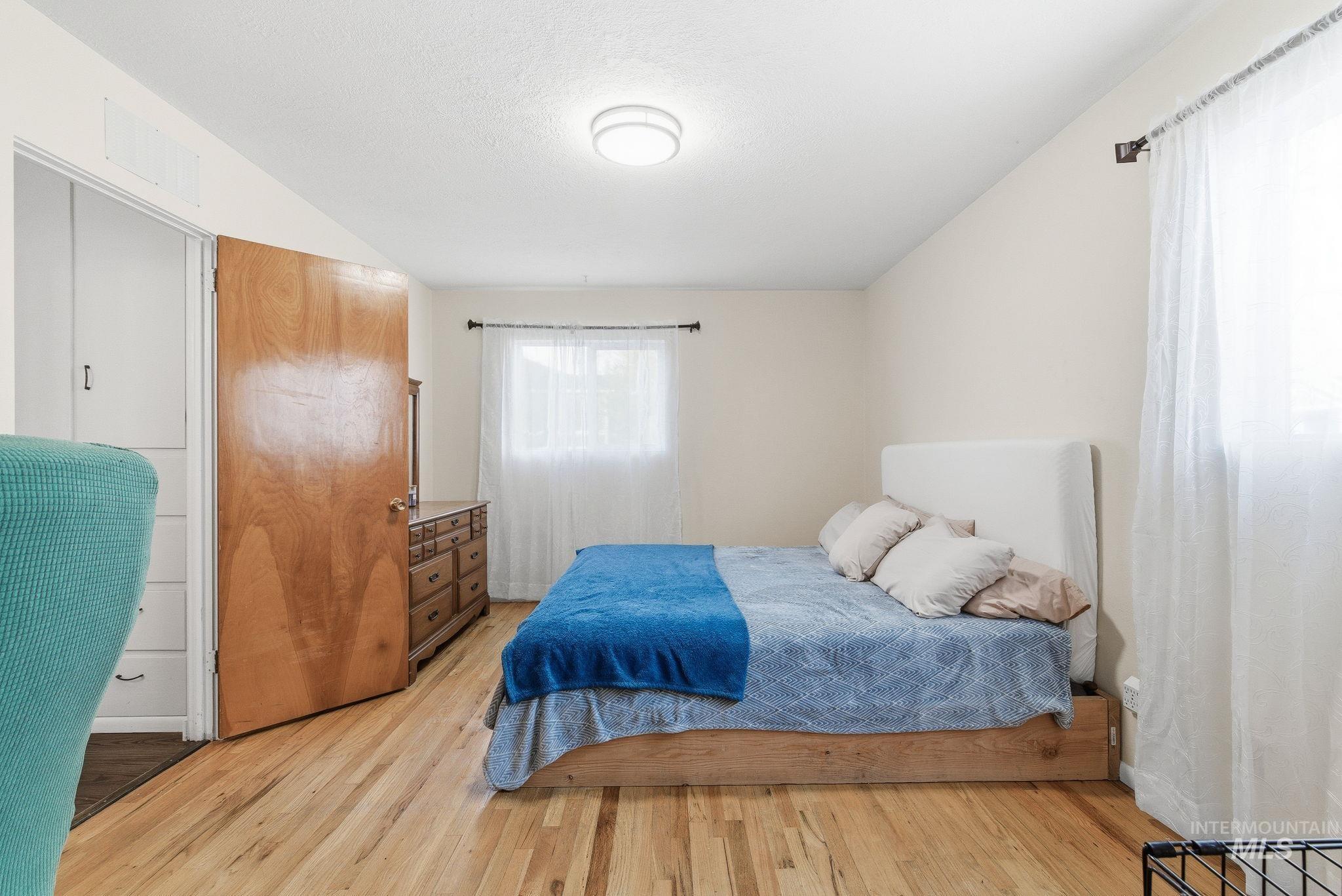 Bedroom featuring light wood-type flooring and a textured ceiling