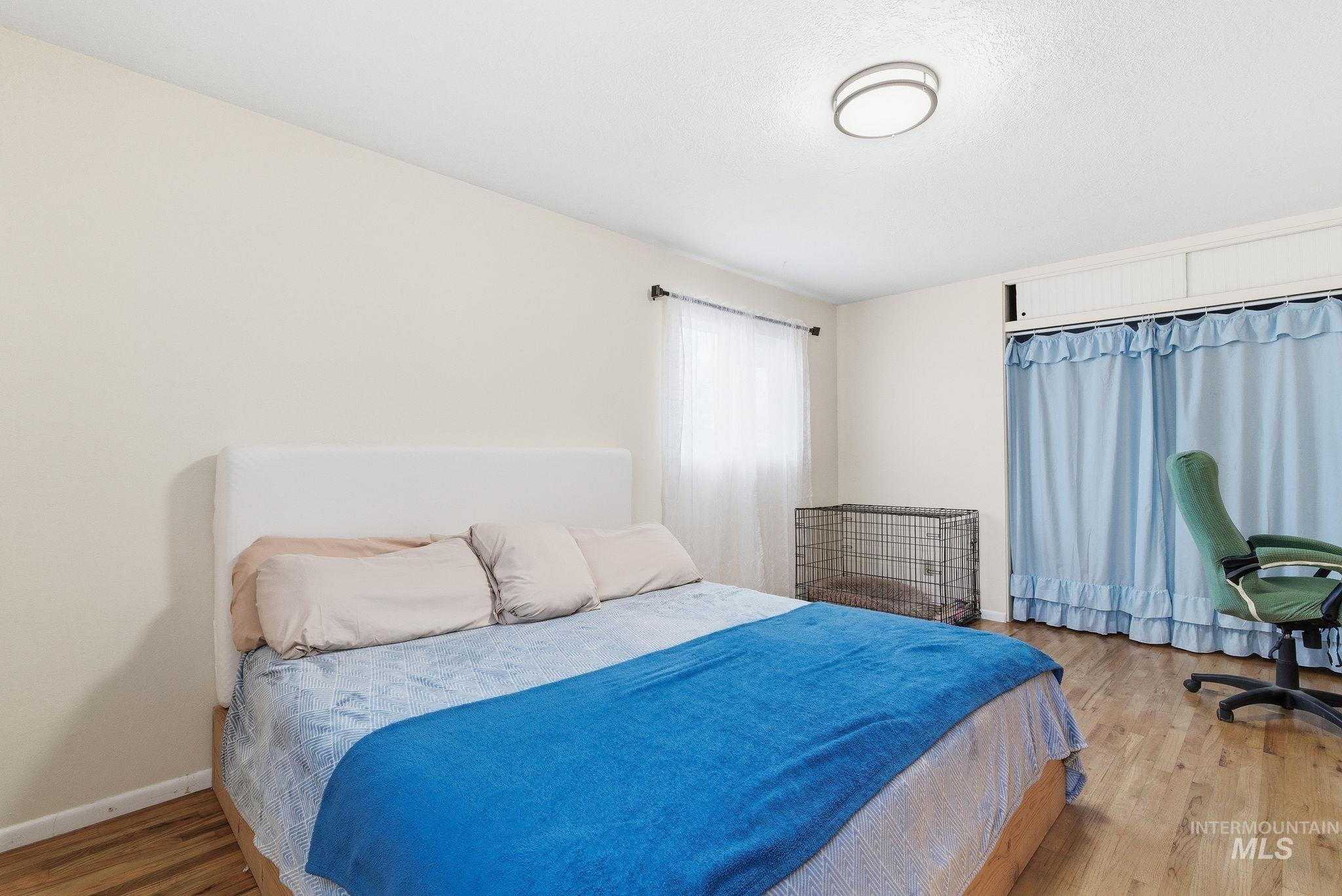 Bedroom featuring wood finished floors and baseboards