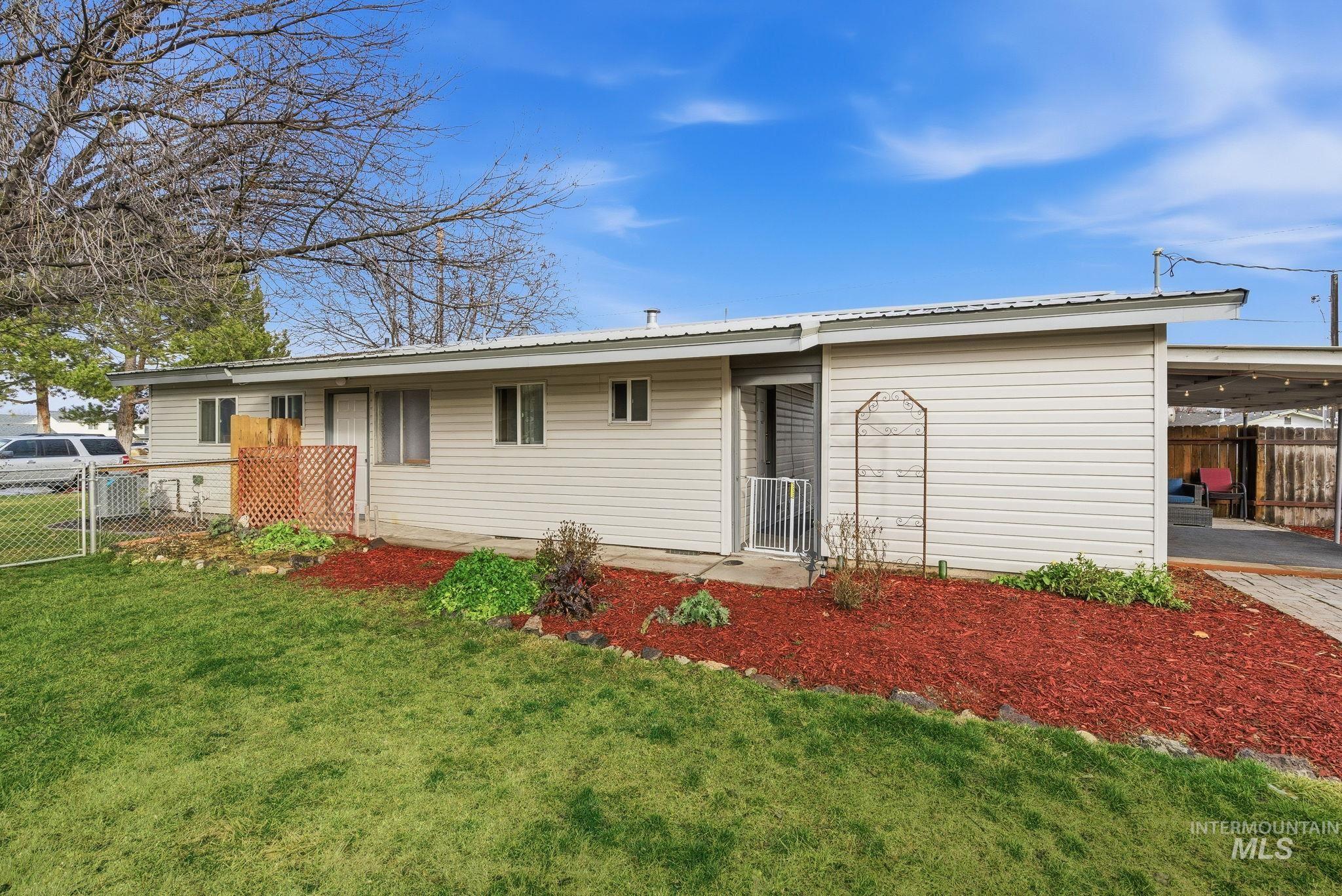 View of front of property featuring a metal roof and a gate