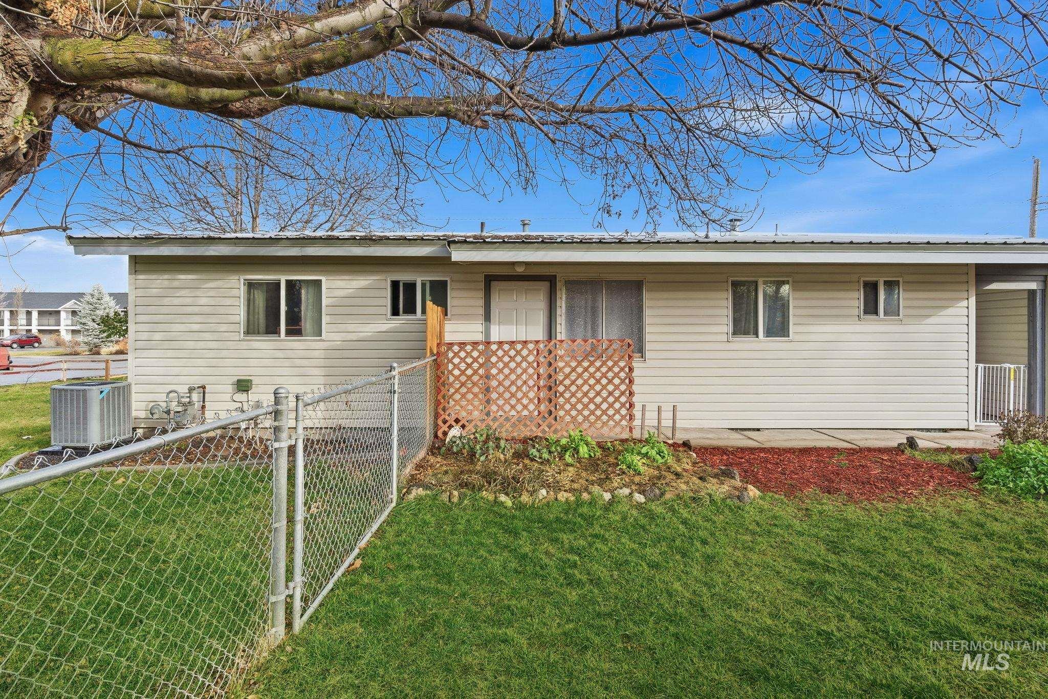 Ranch-style house featuring a metal roof and a gate