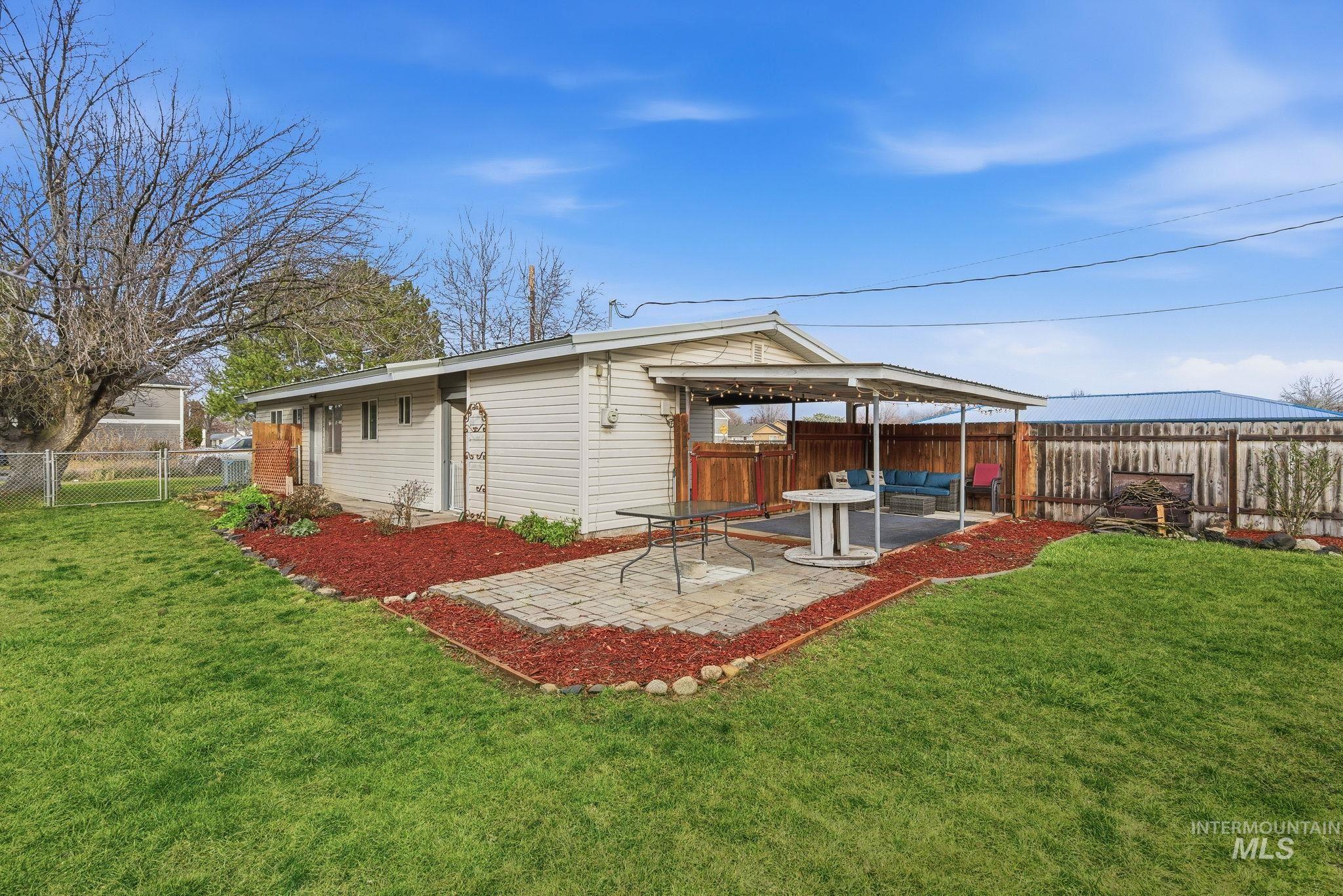 Rear view of house with a fenced backyard, a patio, and a gate