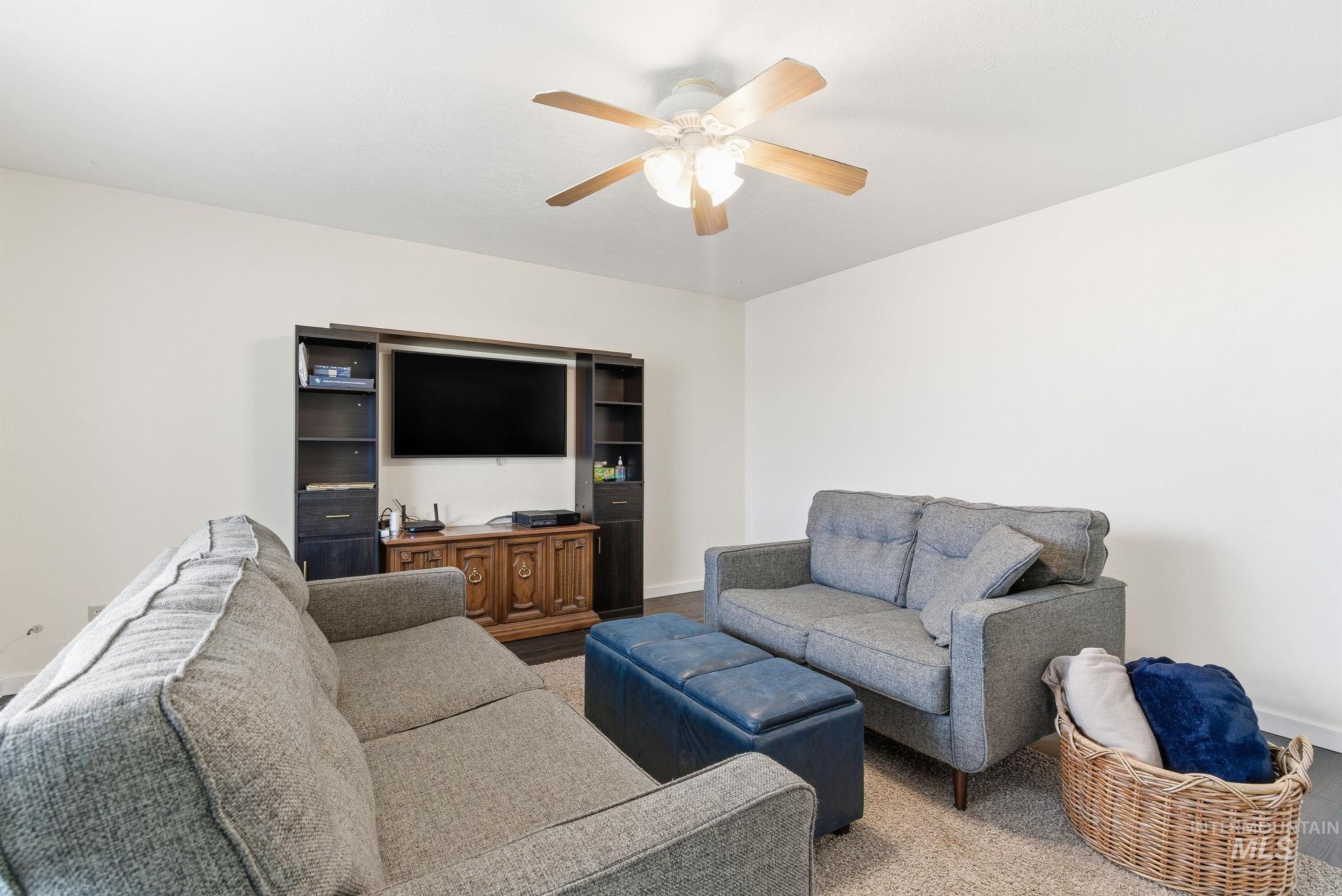 Living area with baseboards and ceiling fan