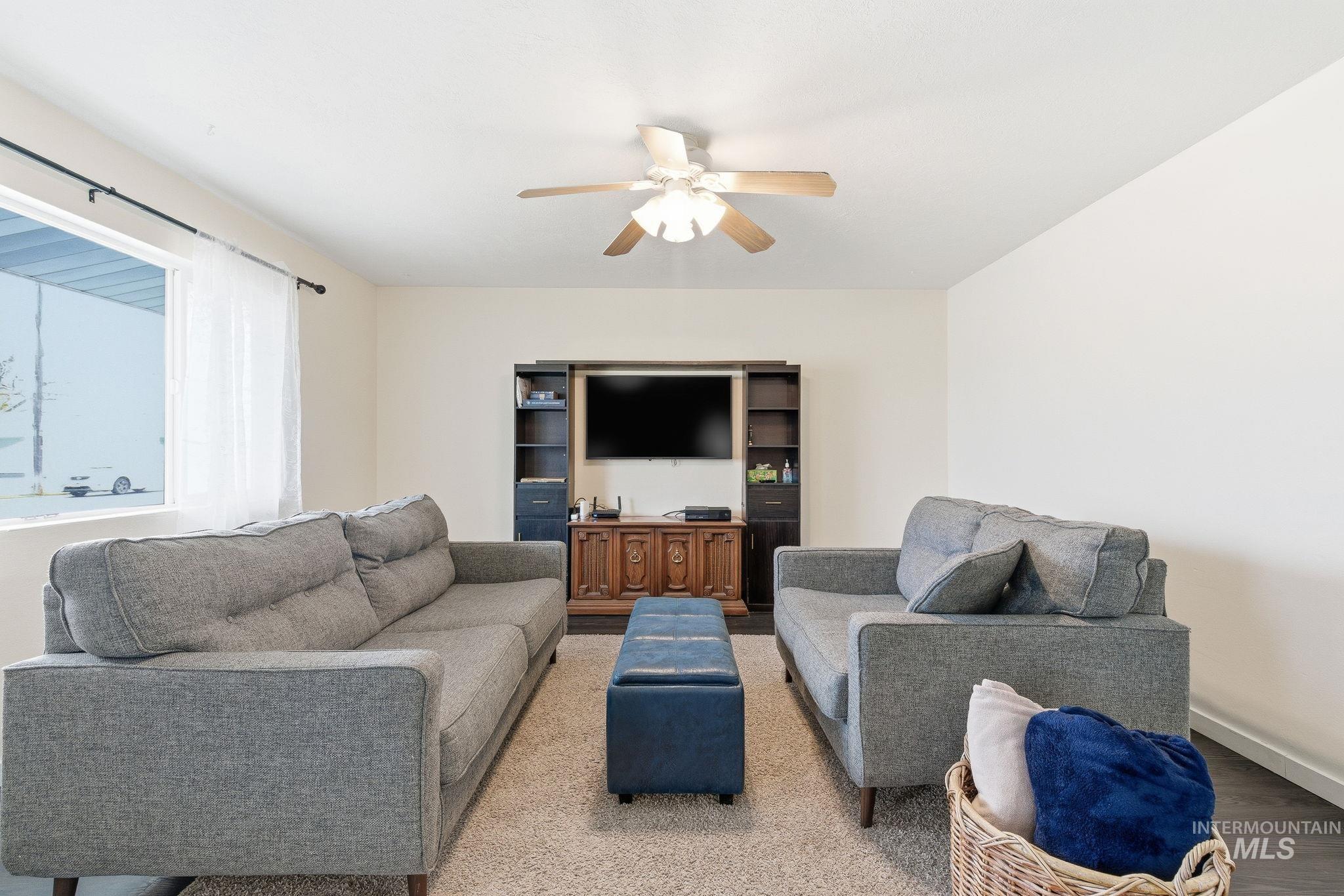 Living area featuring ceiling fan and baseboards