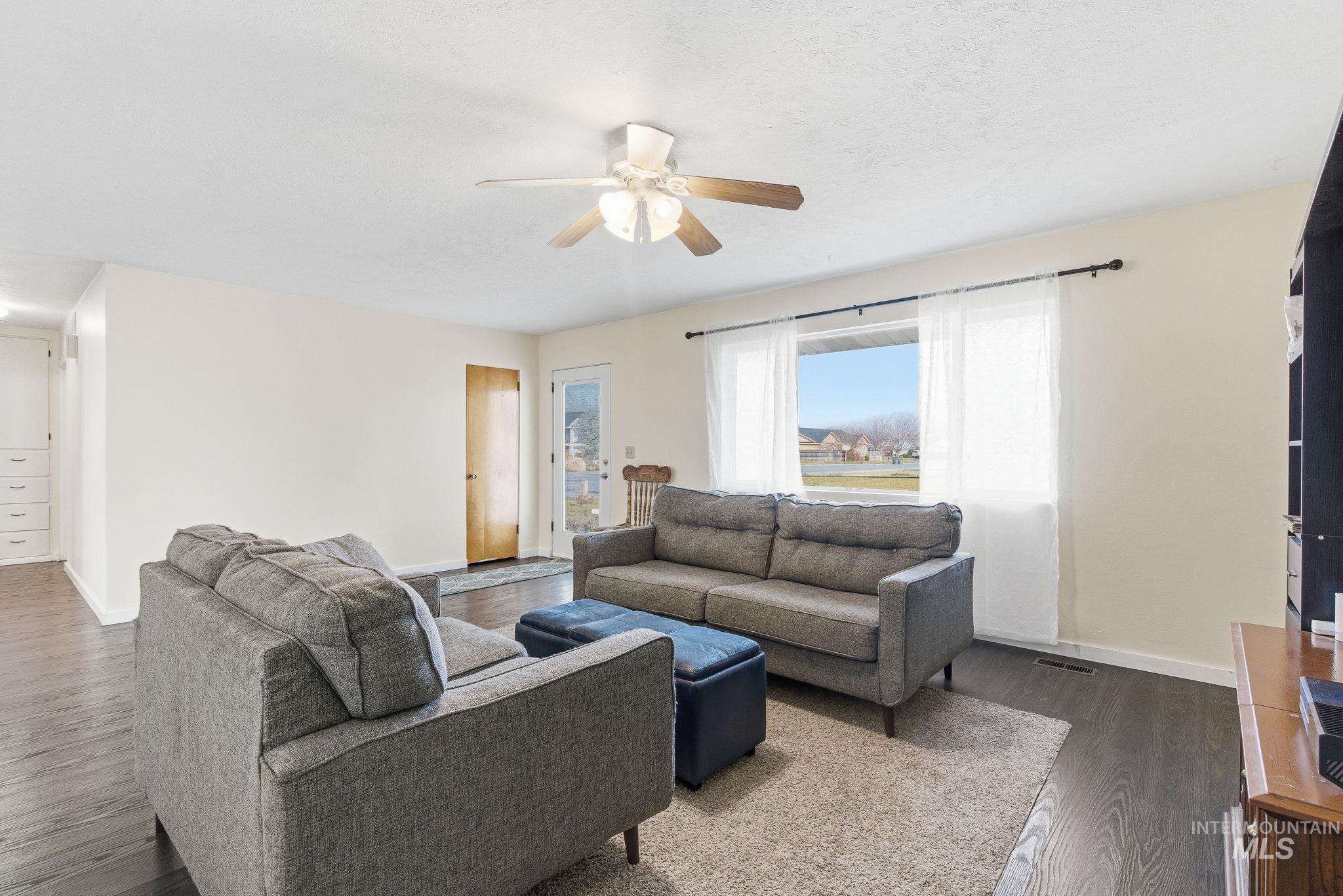Living room with ceiling fan and dark wood finished floors