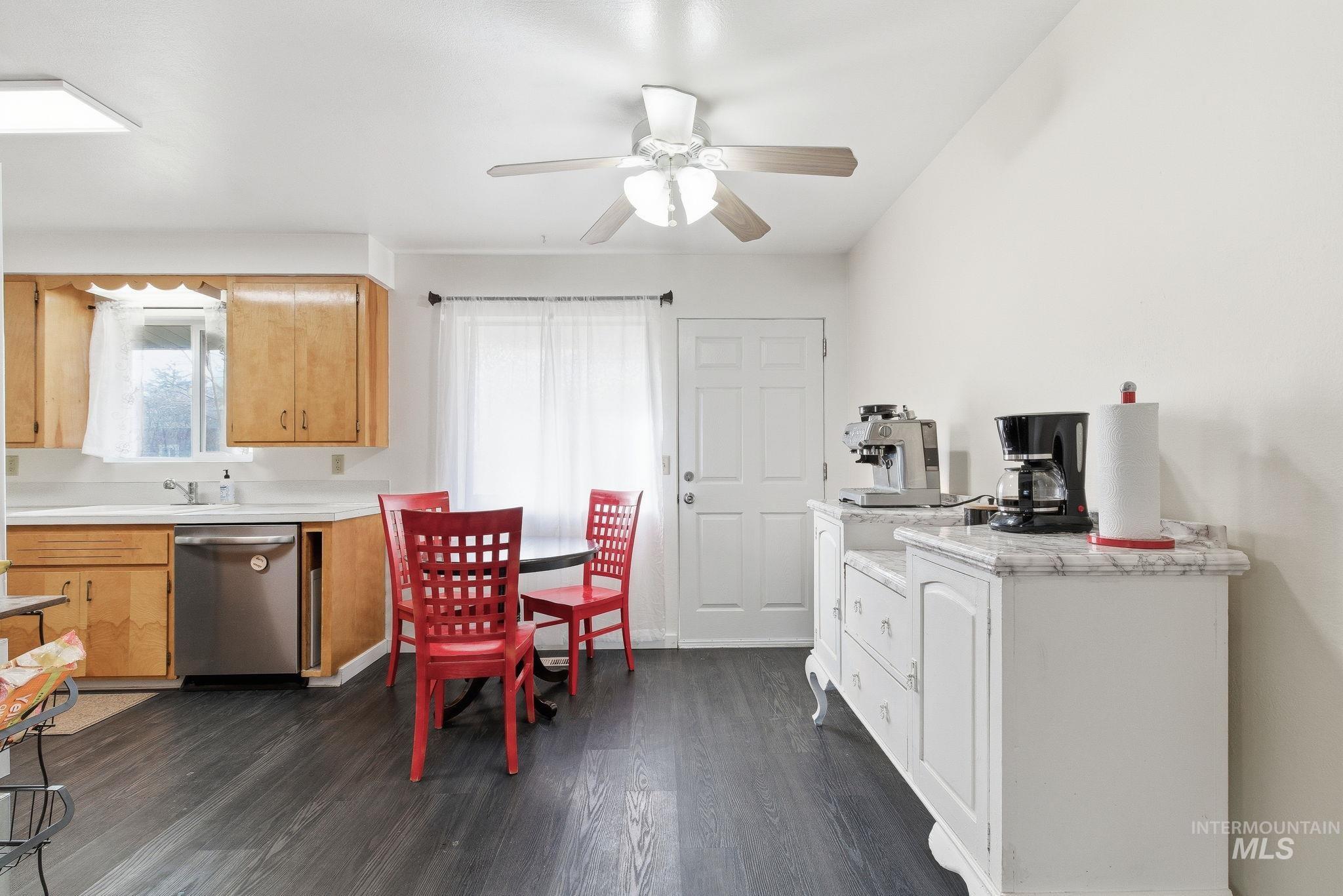 Kitchen featuring light countertops, dishwasher, dark wood-style flooring, and a ceiling fan