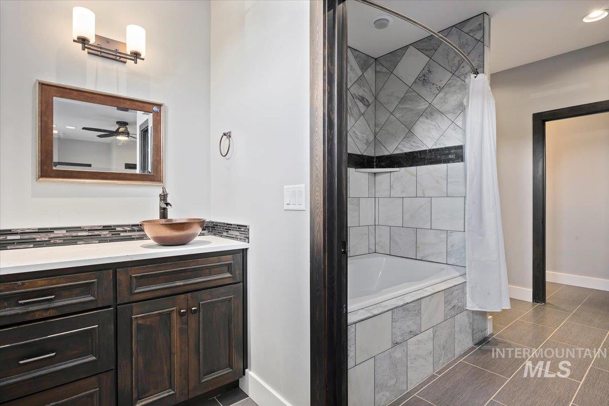 Bathroom with tiled shower / bath and vanity