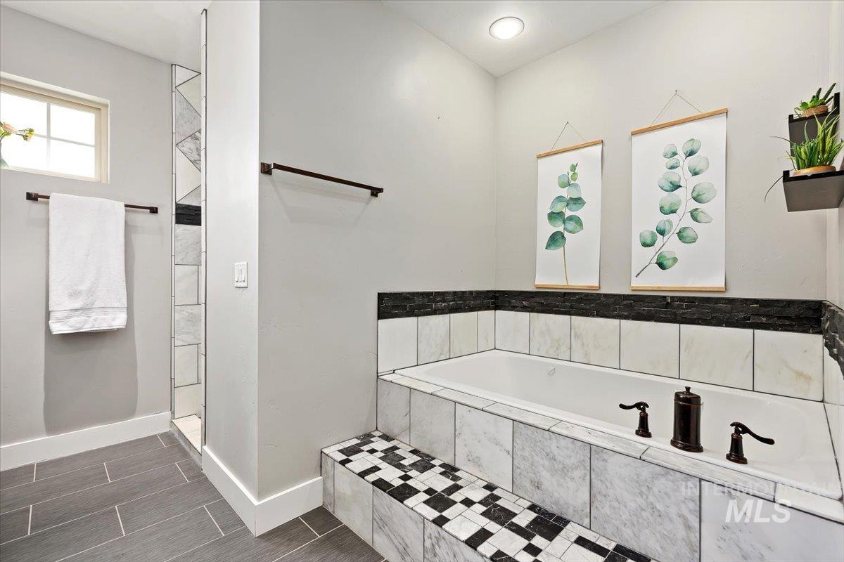Bathroom featuring a bath and baseboards