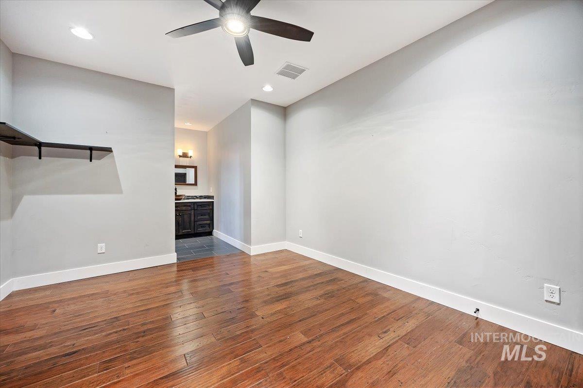 Unfurnished living room featuring dark wood-style flooring, ceiling fan, and recessed lighting