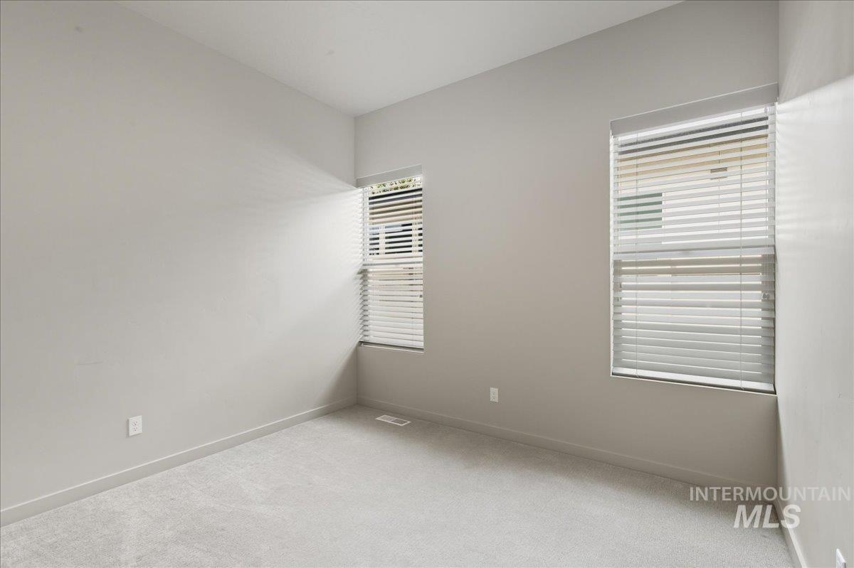 Carpeted spare room with baseboards