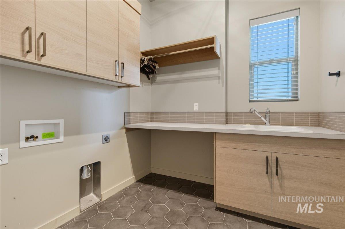 Laundry area with cabinet space, dark tile patterned flooring, electric dryer hookup, and hookup for a washing machine