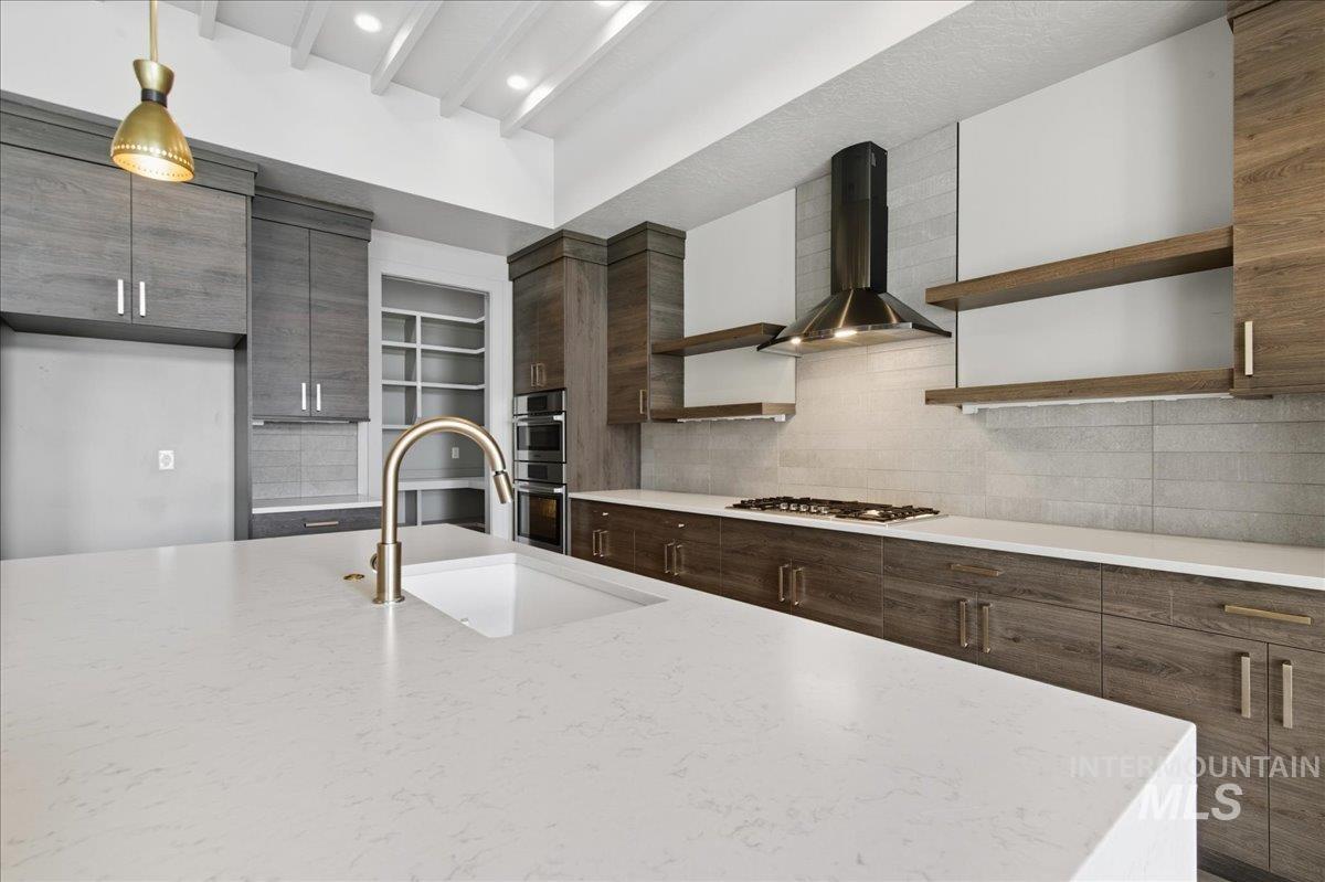 Kitchen featuring open shelves, tasteful backsplash, modern cabinets, and beamed ceiling