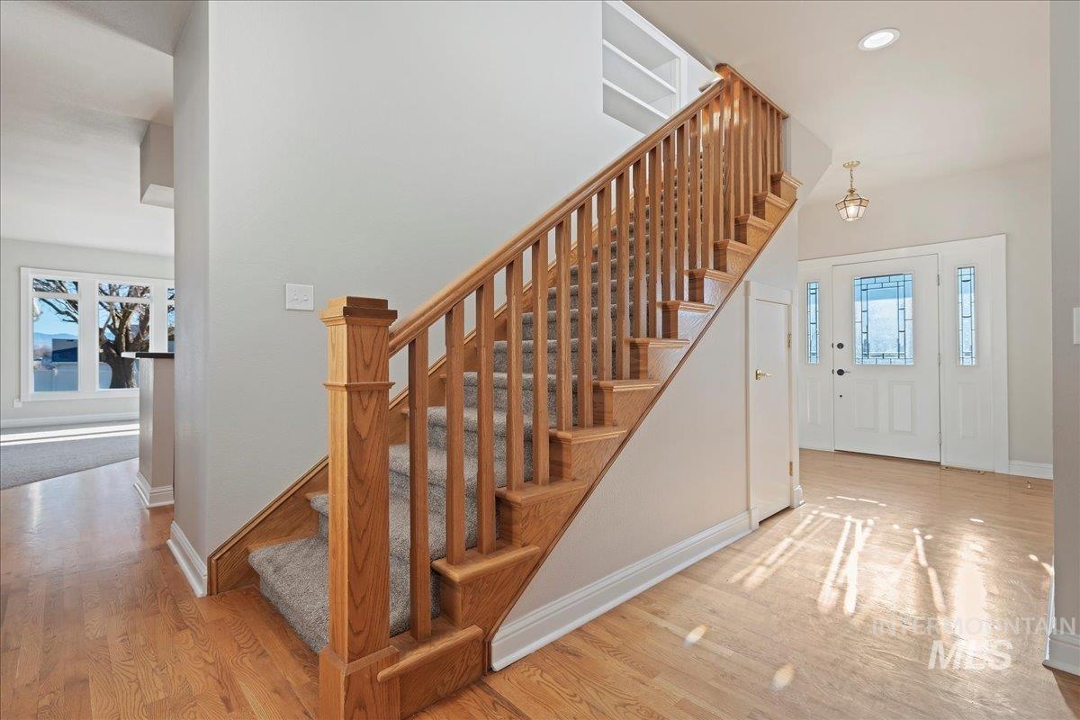 Foyer entrance with stairway, light wood-style flooring, and recessed lighting