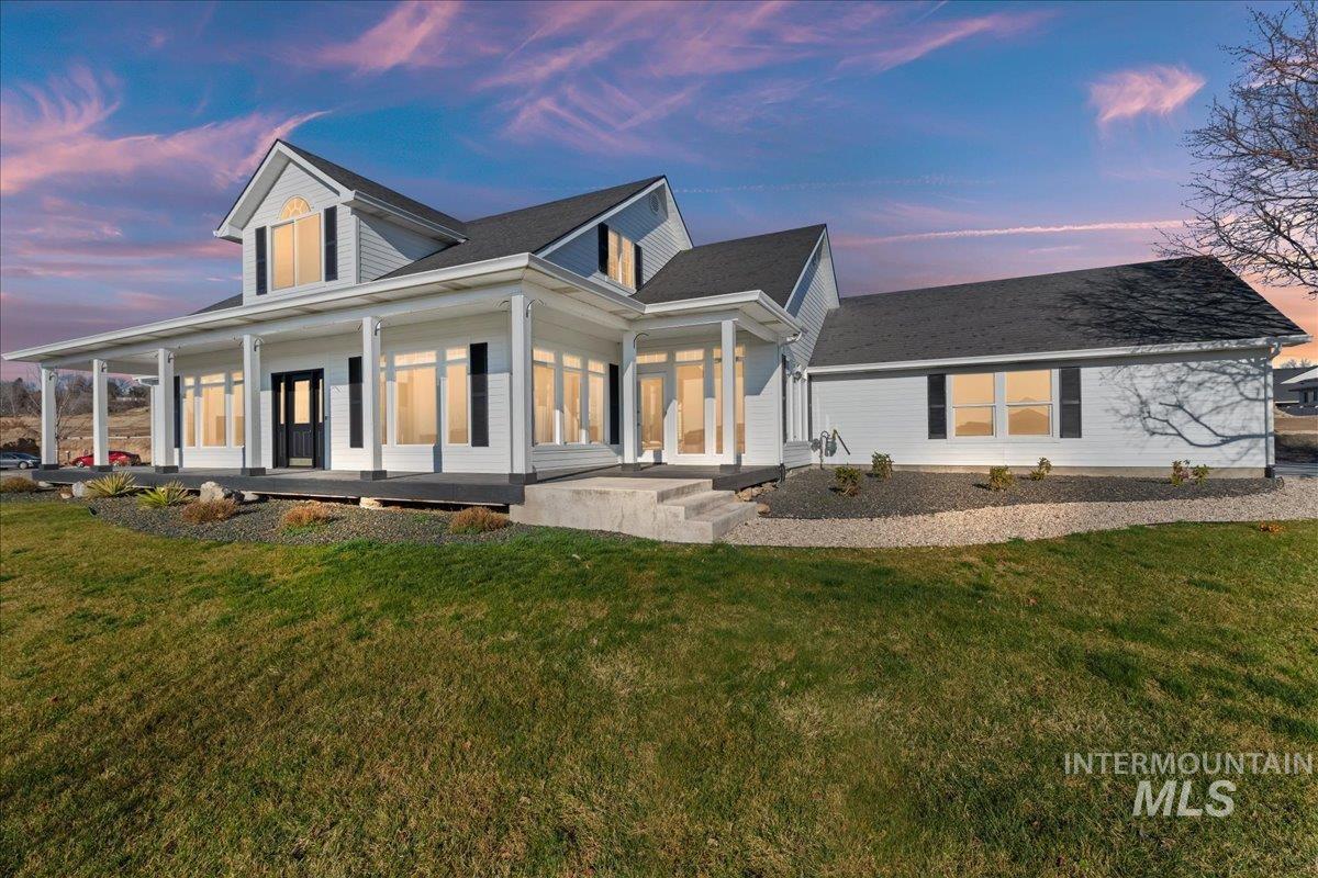 View of front of house with covered porch and a lawn