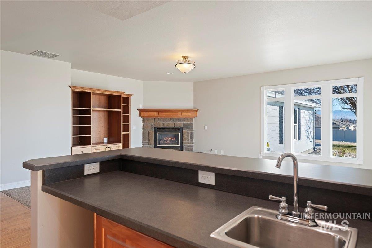 Kitchen with dark countertops, a fireplace, and open floor plan
