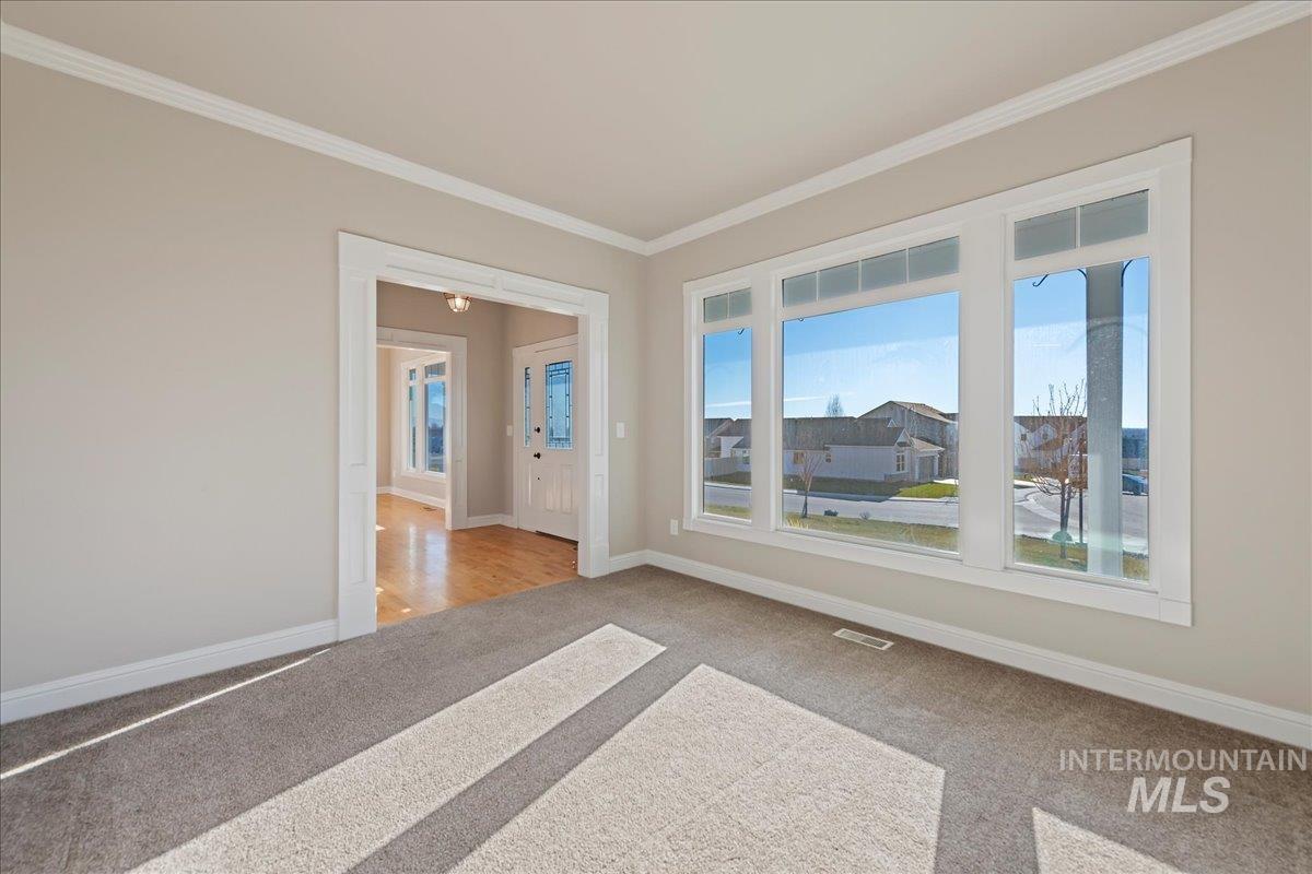 Unfurnished room featuring crown molding and light colored carpet