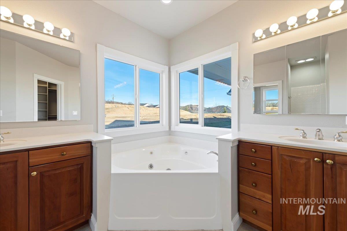 Bathroom with a whirlpool tub and two vanities