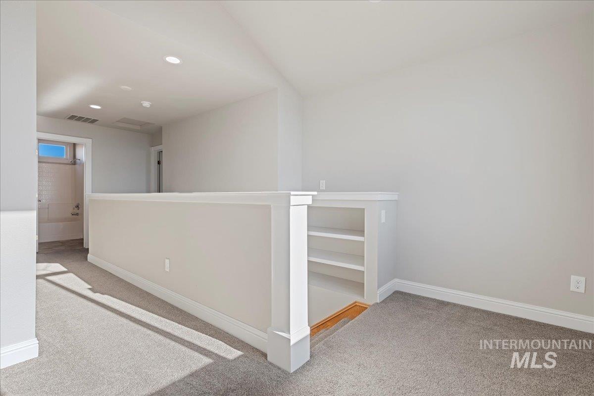 Hall featuring light colored carpet, an upstairs landing, and recessed lighting