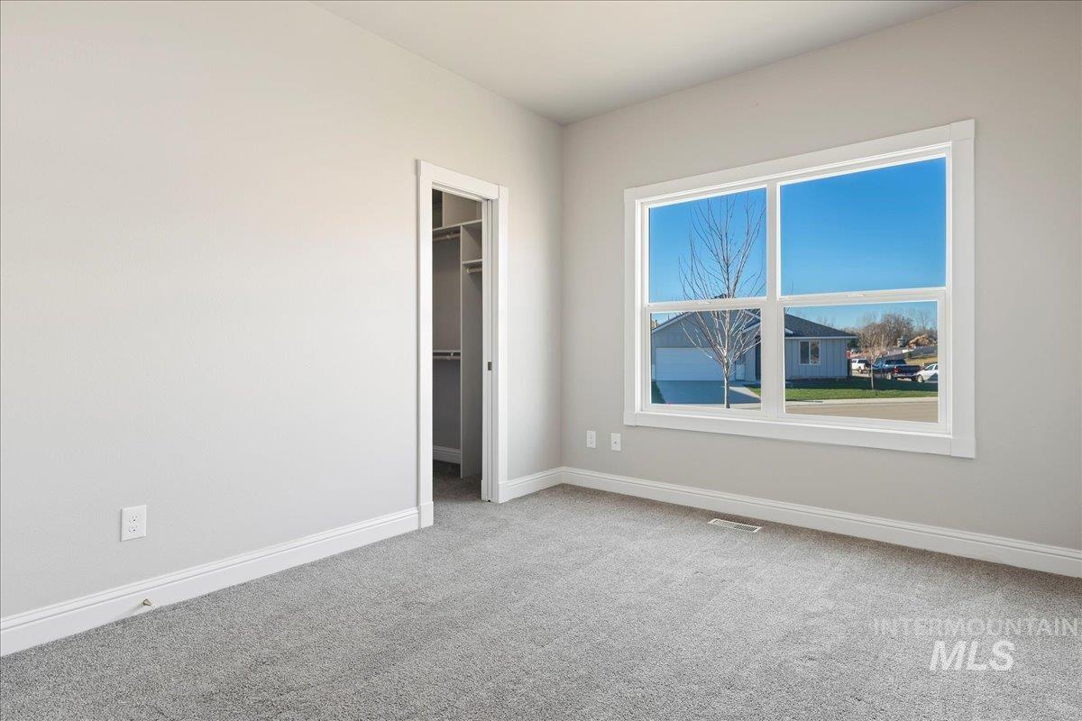 Unfurnished bedroom featuring a spacious closet and light colored carpet