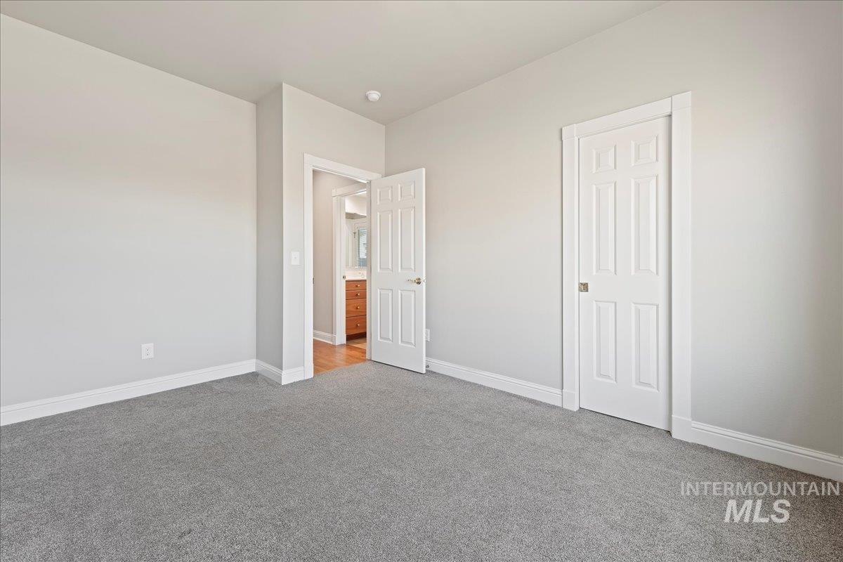 Unfurnished bedroom featuring carpet floors and baseboards