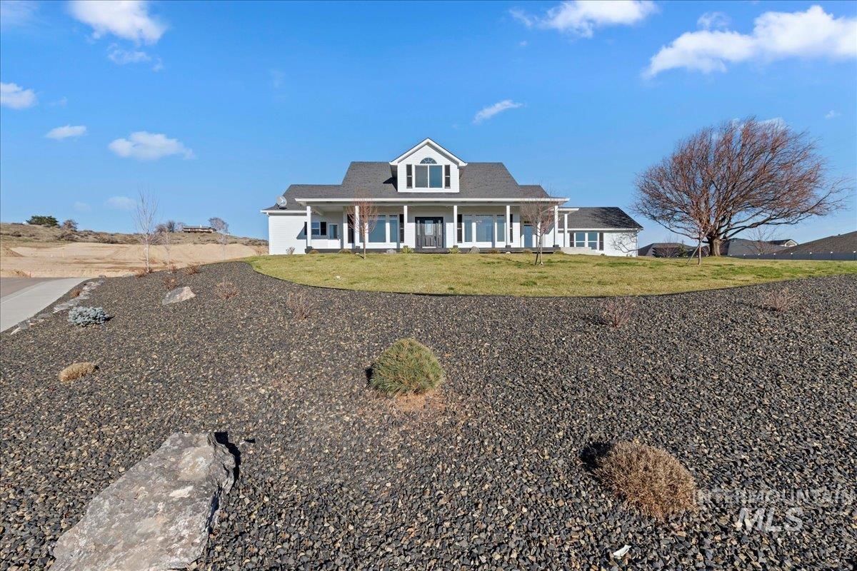 View of front facade with covered porch and a front yard