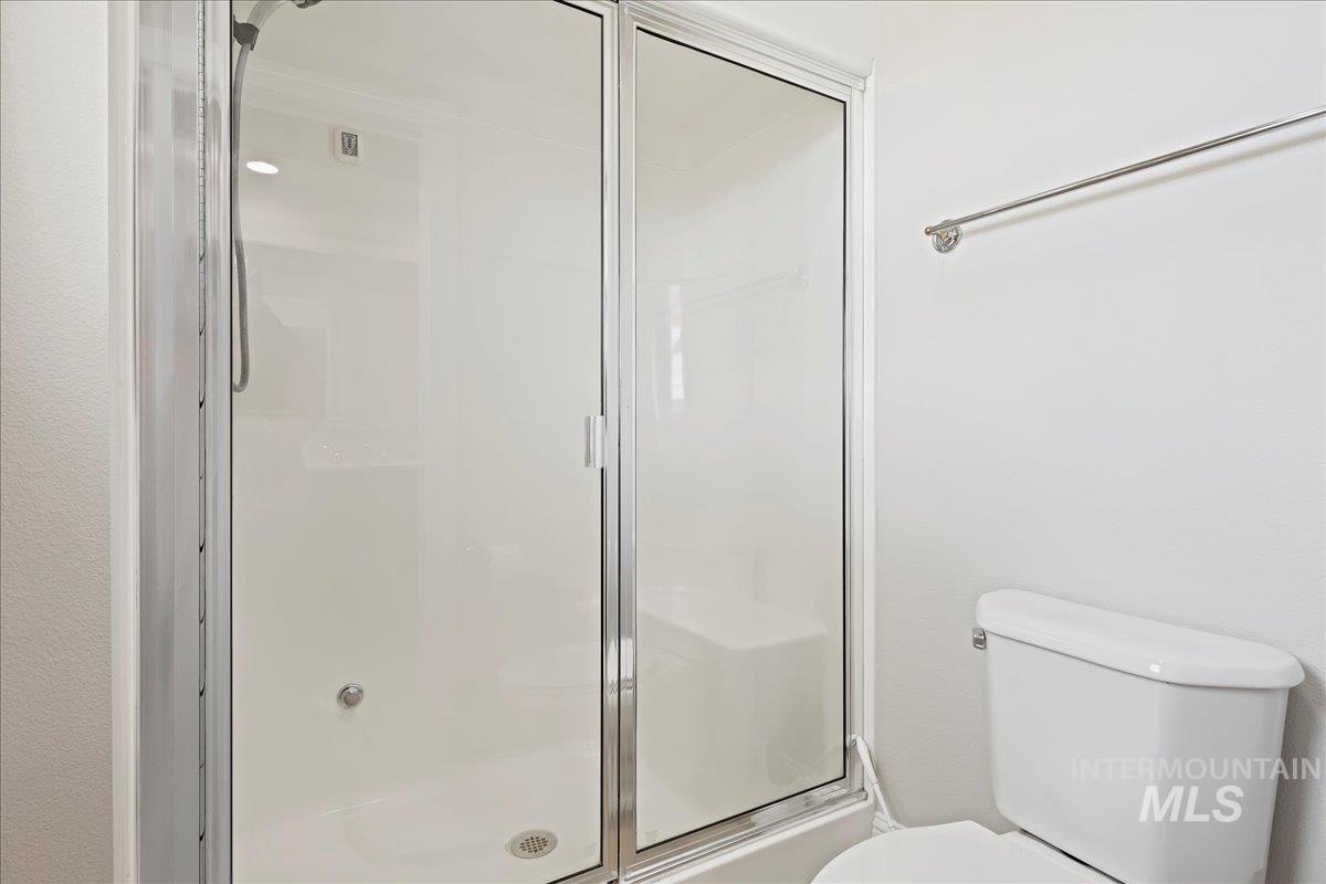 Full bath featuring a stall shower and toilet