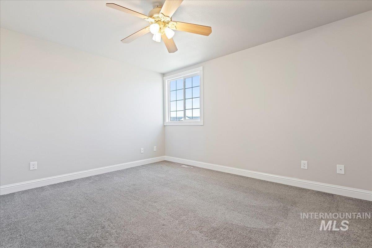 Unfurnished room with carpet floors and a ceiling fan