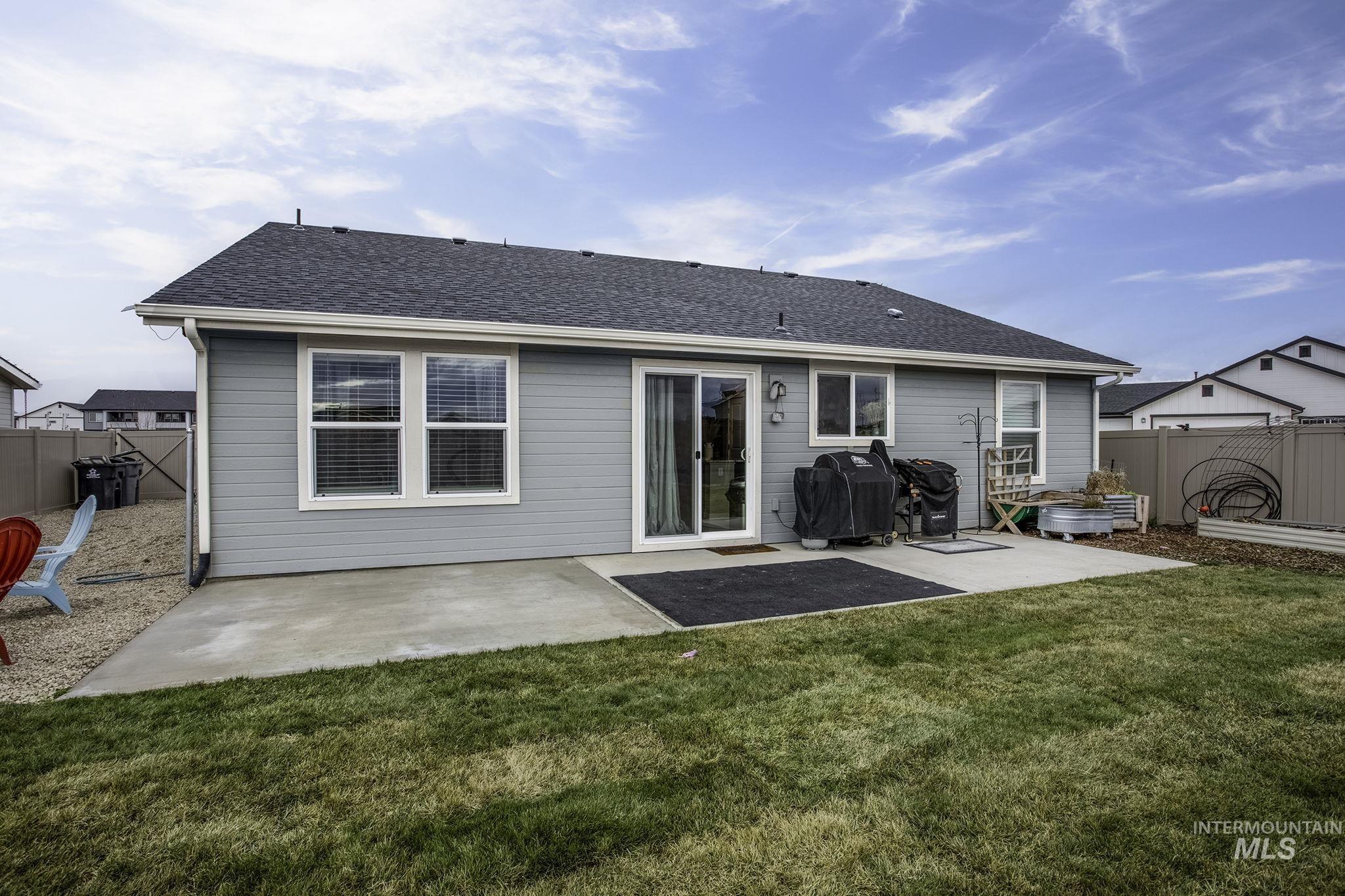 Rear view of property featuring a patio, a fenced backyard, and a shingled roof