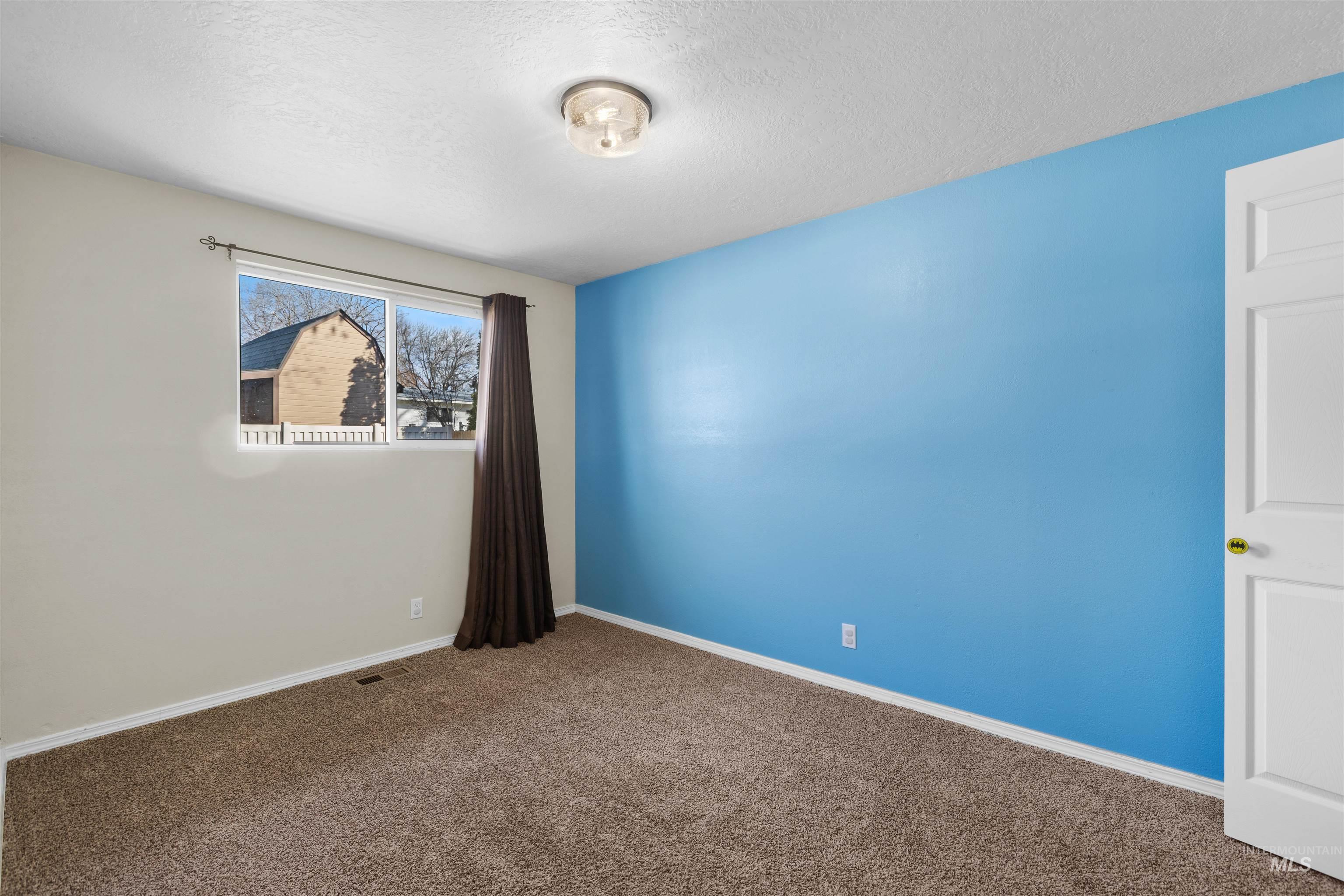 Spare room featuring a textured ceiling and carpet