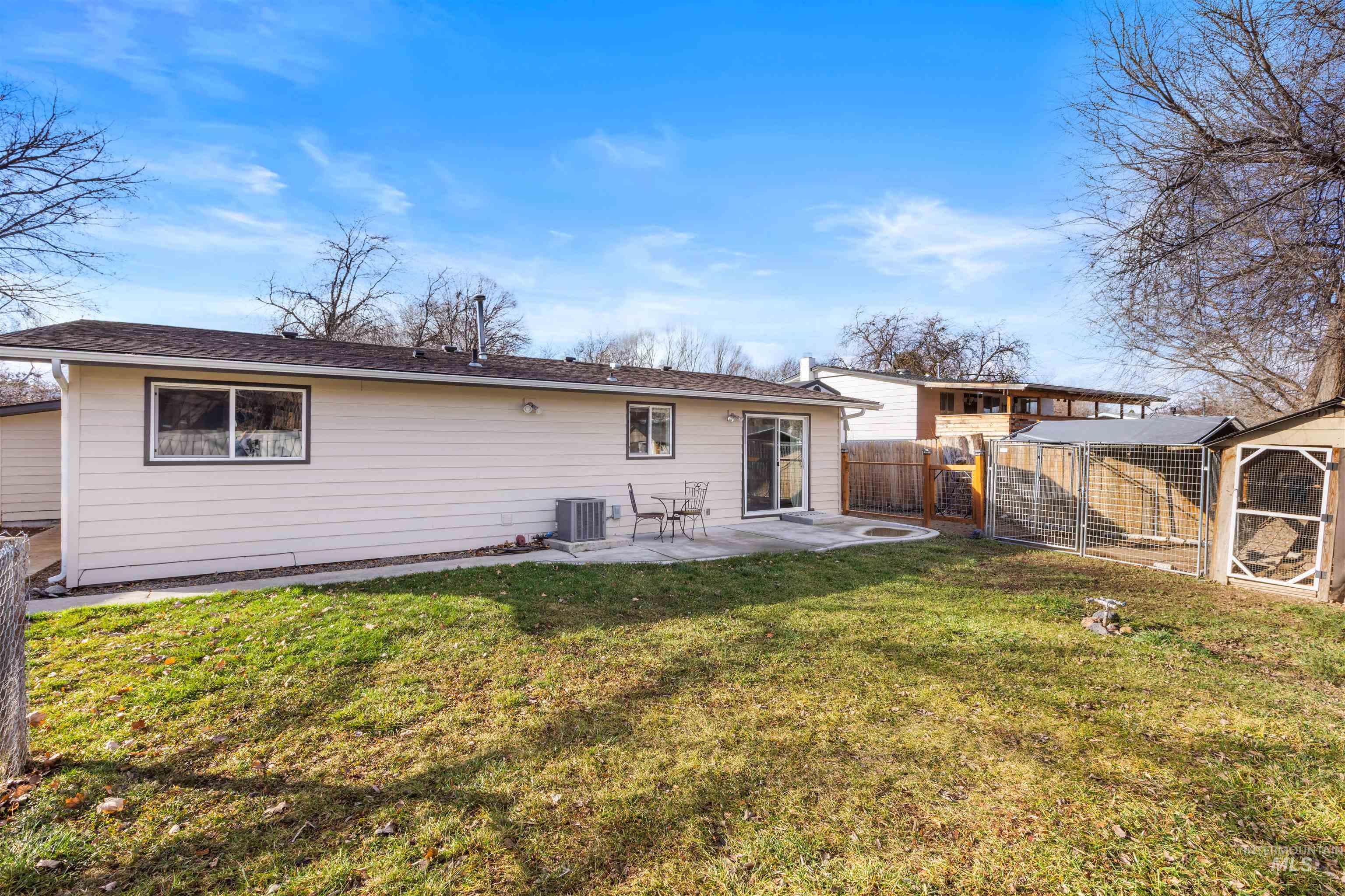 Back of house featuring a patio area and an outbuilding