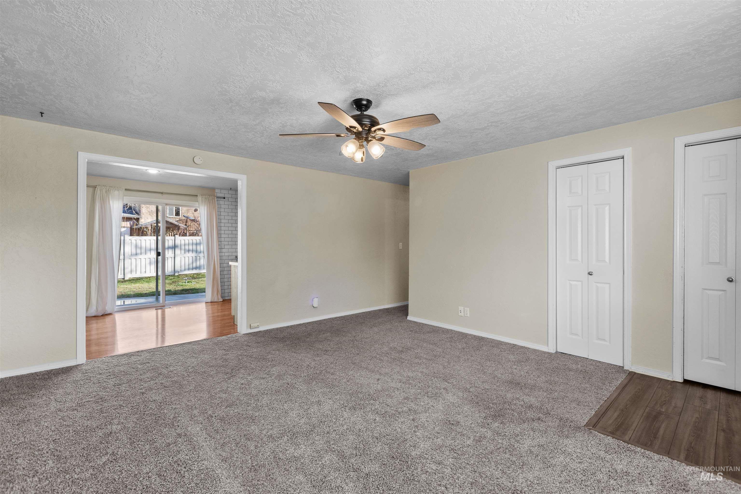 Spare room featuring carpet, ceiling fan, and a textured ceiling