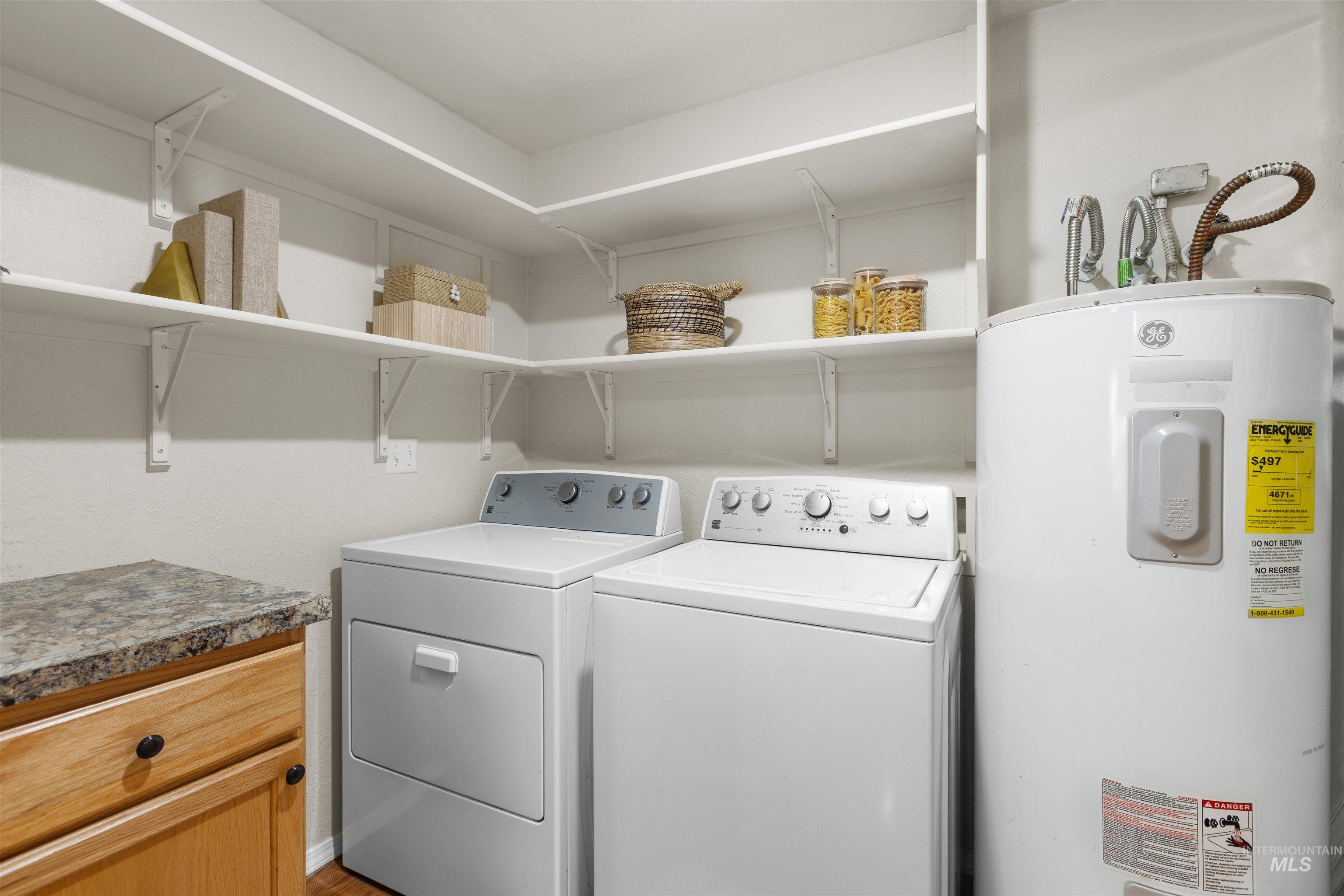 Washroom featuring electric water heater and washer and dryer
